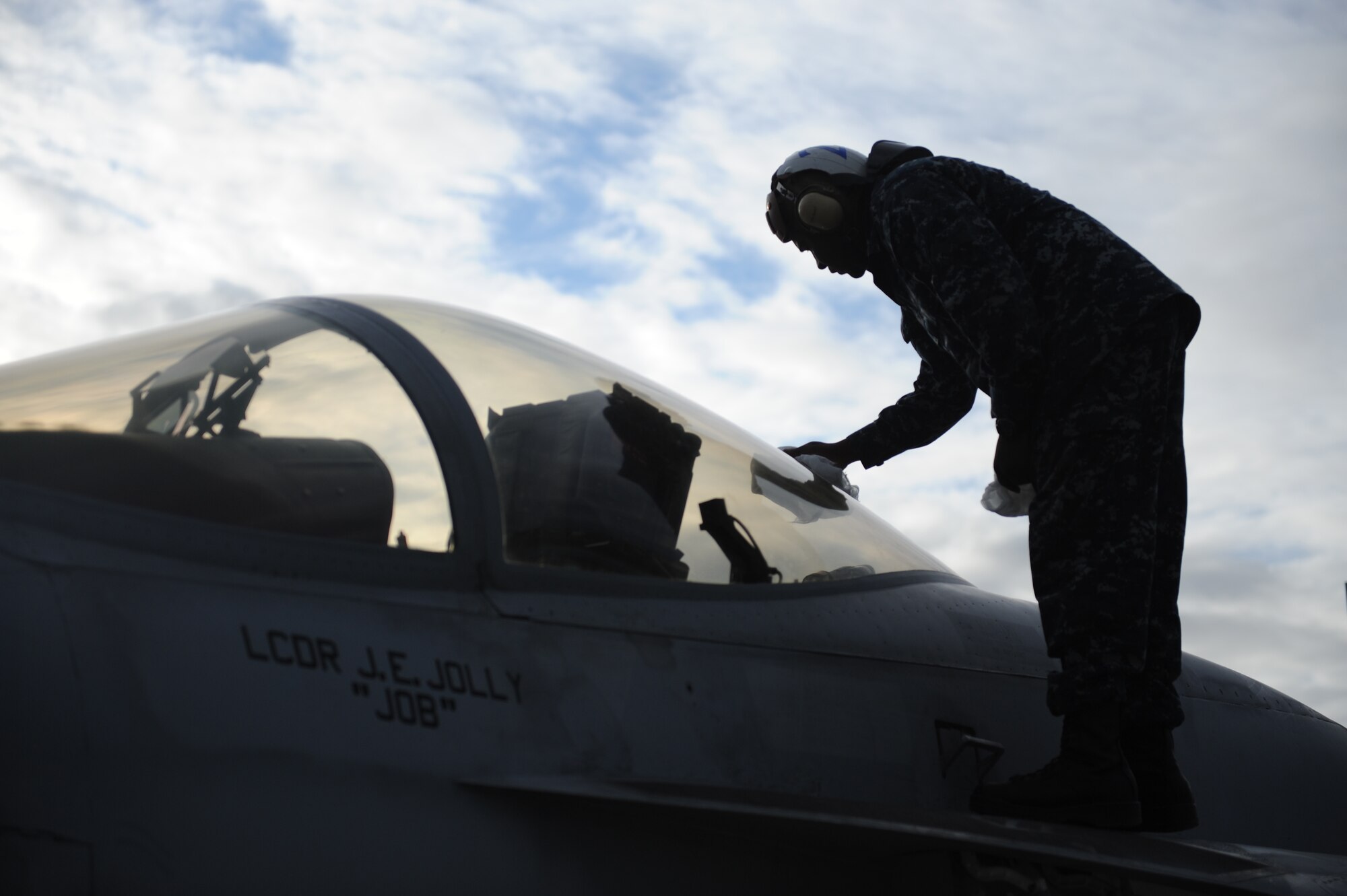 JOINT BASE ELMENDORF RICHARDSON, Alaska --  Aviation Machinist Mate Airman Richard Wells cleans the canopy of an F/A-18F Super Hornet prior to it's first flight in support of Operation Northern Edge 11 in JBER, Alaska, June 13, 2011. Northern Edge, Alaska's largest military training exercise, is designed to prepare joint forces to respond to crises throughout the Asia-Pacific region. (Photo by Mass Communication Specialist 2nd Class Rufus Hucks)