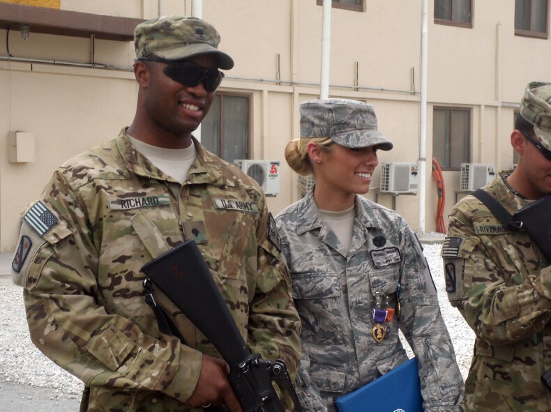 Airman 1st Class Bryenna Brooks, a medic with the 101st Special Troops Battalion, 101st Sustainment Brigade, deployed from Barksdale Air Force Base, La., stands with Army Spc. Craig Richard Jr., of the 59th Quartermaster Company, 142nd Combat Sustainment Support Battalion, 101st Sustainment Brigade, after Brooks received four awards, including a Purple Heart Medal. Airman Brooks and Specialist Richard were in a vehicle with three other Soldiers of the 59th Quartermaster Company, when their vehicle took a rocket propelled-grenade during a resupply convoy mission recently. (courtesy photo)(RELEASED)