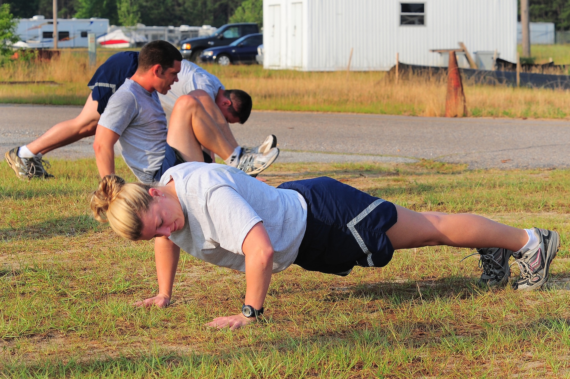 Capt. Sarah Eccles, 682nd Air Support Operations Squadron air liaison officer, and Staff Sgts. Brian Rhodes and Justin Shoffner, 682nd ASOS logistics personnel, work out during squadron physical training June 13, 2011. Captain Eccles is also an F-16 pilot who is currently on non-flying status during her alpha tour as an ALO. (U.S. Air Force photo/Airman 1st Class Daniel Phelps)