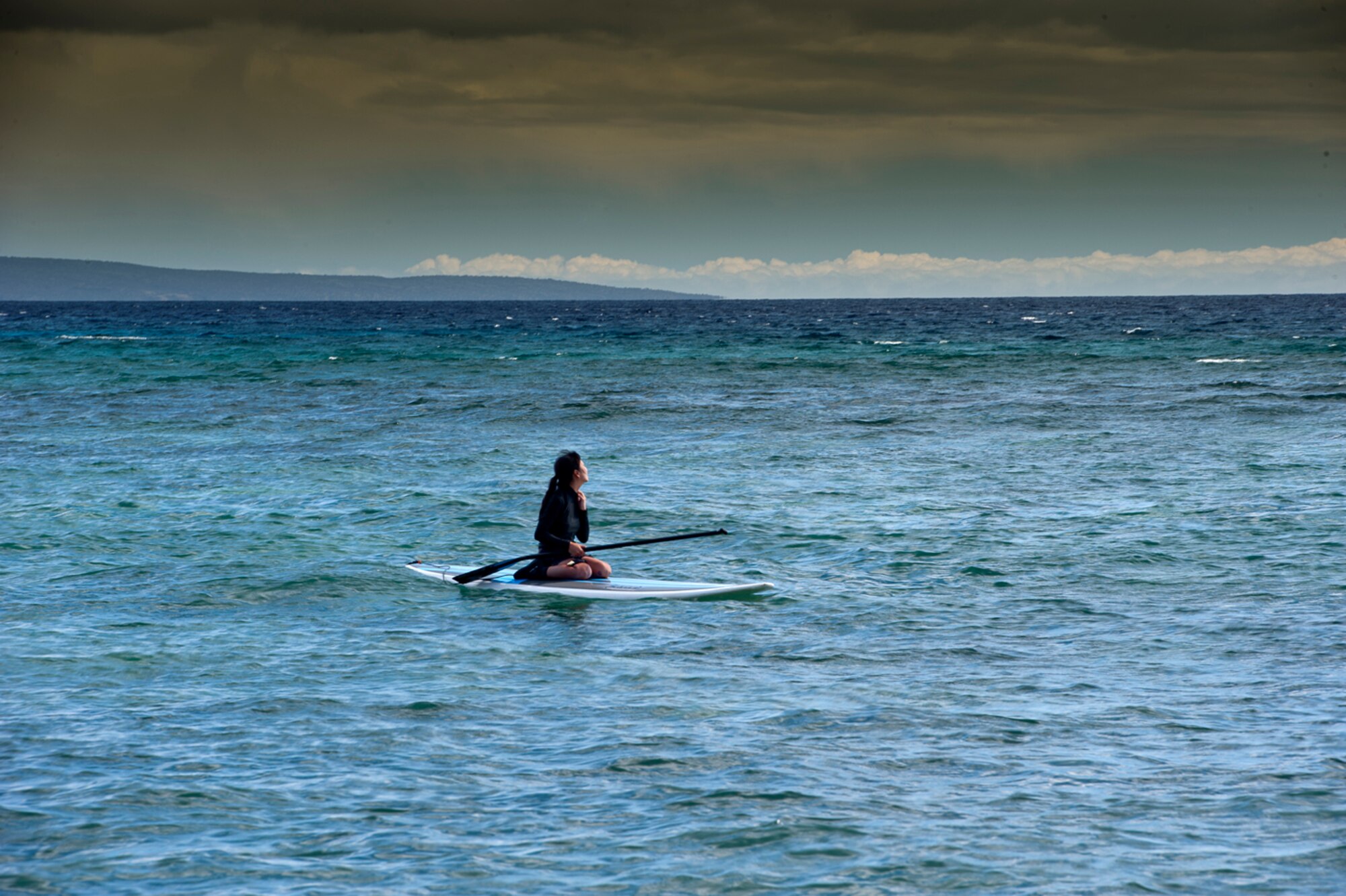 MESSIN WITH PARADISE - Waiting for the next big wave? This paddle surfer may be. But she wants no part of the monster waves tsunamis produce. (Photo by TSgt Samuel Bendet)