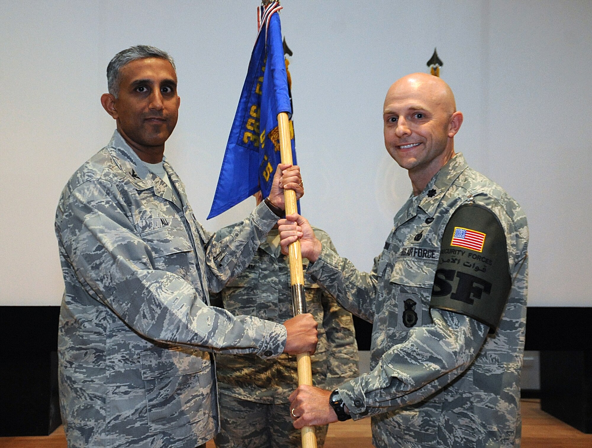 Col. Rizwan Ali, 386th Expeditionary Mission Support Group commander, left, passes the 386th Expeditionary Security Forces Squadron guide-on to Lt. Col. Gregory Nowak June 13 during a change of command ceremony at an undisclosed location in Southwest Asia. Colonel Nowak assumed command of the 386th ESFS from Lt. Col. Philip Holmes. (U.S. Air Force photo by Senior Airman Cynthia Spalding)