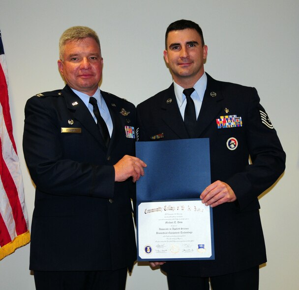 Tech. Sgt. Michael Dow, medical administrator, 103rd Medical Group, receives his diploma from the keynote speaker Col. Thomas Powers, commander, 103rd Mission Support Group, during the Fall 2010/Spring 2011 CCAF graduation at Bradley Air National Guard Base, East Granby, Conn. May 14, 2011.
