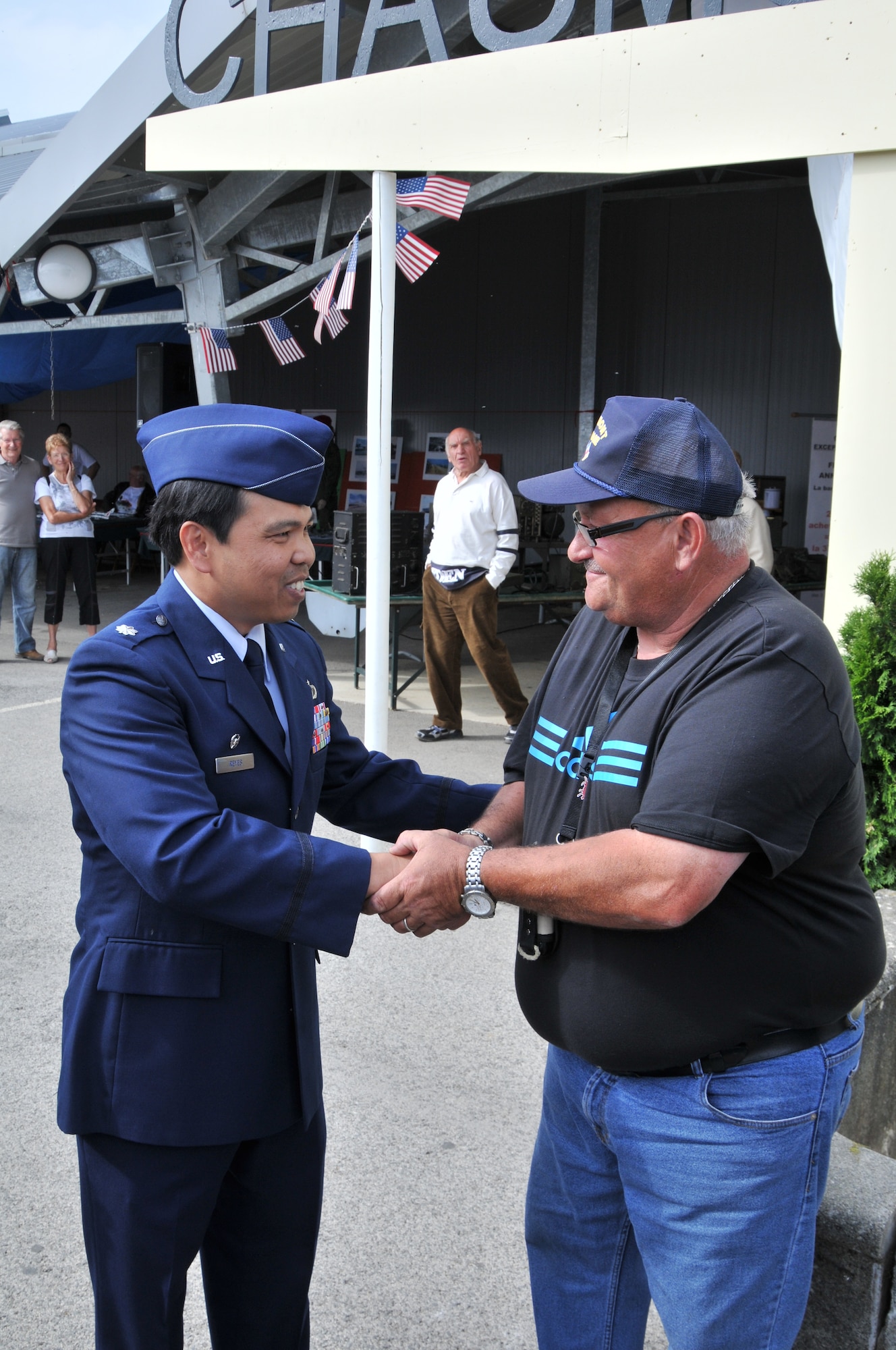 VILLIERS-LE-SEC, France -- Lt. Col. Raymond Reyes, 48th Contracting Squadron commander, coins Jacky Rusnov at an exhibition of American military artifacts here June 12, 2011. Mr. Rusnov organized the exhibition to celebrate the former Chaumont Air Base, which was home to the 48th Fighter Wing from 1952 to 1967. (U.S. Air Force photo/Senior Airman David Dobrydney)
