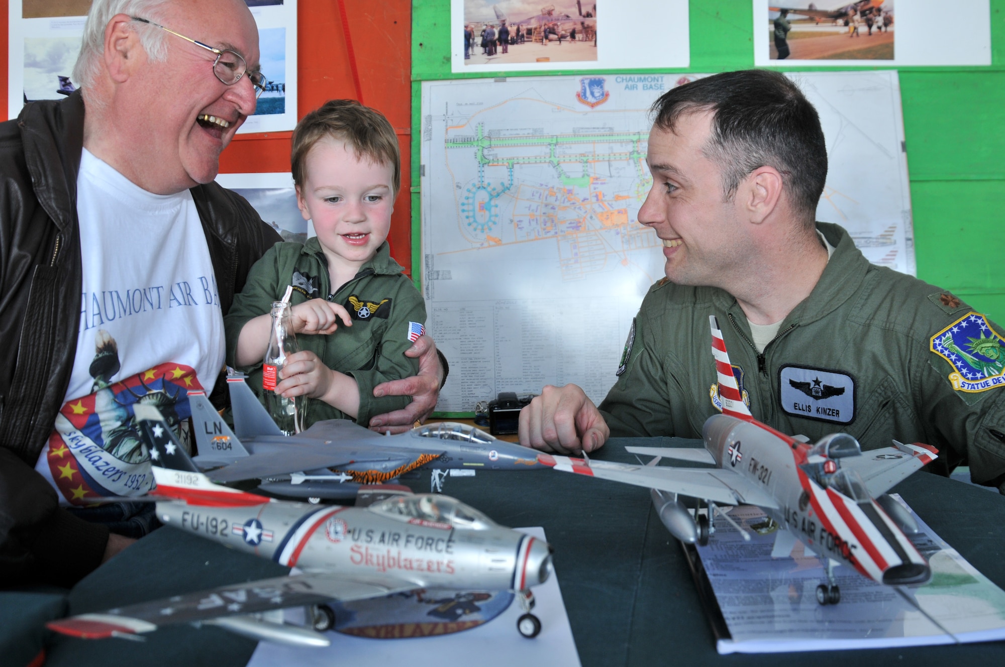 VILLIERS-LE-SEC, France -- Maj. Ellis Kinzer, 494th Fighter Squadron assistant director of operations, and his son William admire model aircraft built by Jerome Wilhelem (left) at an exhibition here June 12, 2011. Major Kinzer represented the 48th Fighter Wing at the event celebrating the former Chaumont Air Base, which the 48th FW operated from 1952 to 1967. The two models in the foreground are models of aircraft which were once based at Chaumont. (U.S. Air Force photo/Senior Airman David Dobrydney)