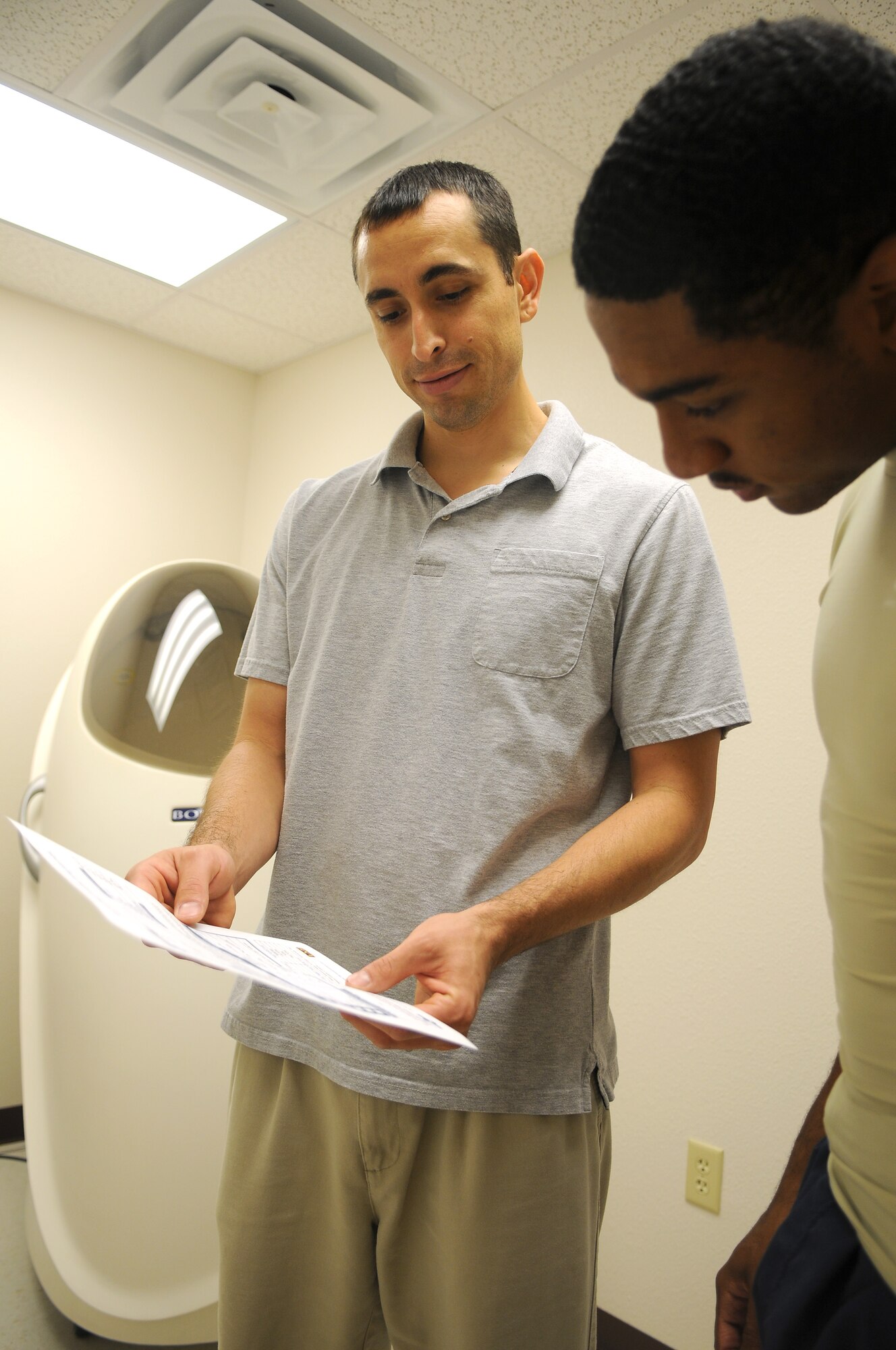 GOODFELLOW AIR FORCE BASE, Texas - Mr. Carlos Sifuentes, Health and Wellness Center health promotion educator, reads BOD POD test results to Airman 1st Class Michael Smith at the Health and Wellness Center June 10. This test provides a breakdown of Airman Smith's body composition as well as caloric intake based on his activity level. (U.S. Air Force photo/Staff Sgt. Heather L. Rodgers)
