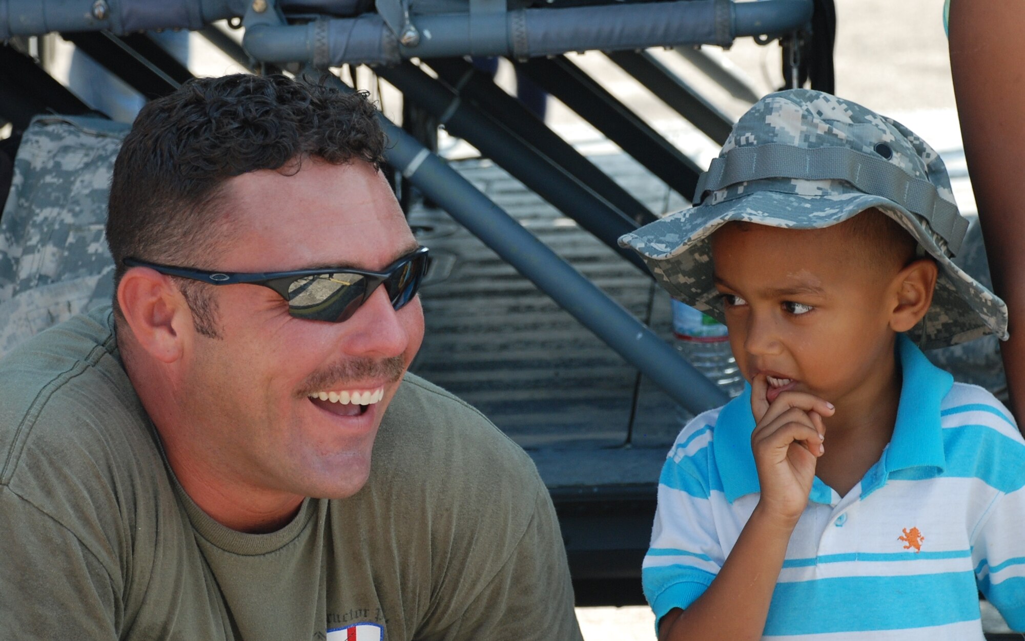 Chief Warrant Officer Brian Hayes shares a smile with a local child during the San Pedro Sula Air Show June 12, 2011, Honduras. Warrant Officer Hayes is from the 1st Battalion, 228th Aviation Regiment, Soto Cano Air Base, Honduras.
