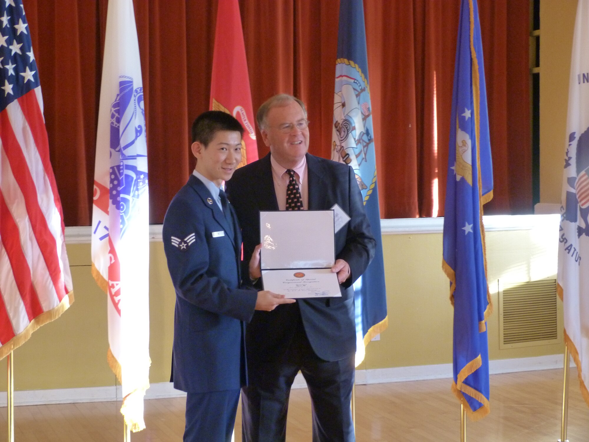 Presidio of Monterey, Calif.—Senior Airman Ziqun He, 17th Force Support Squadron, receives a certificate from Congressman Sam Farr, 17th District of Calif., congratulating him on his acceptance to the Air Force Academy. (courtesy photo)