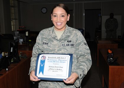 Airman First Class Olivia Besker holds her Top 3 Professional Performer of the Month Award. She is a career development journeyman assigned to the 902nd Force Support Squadron at Randolph Air Force Base, Texas. (U.S. Air Force photo/Dave Terry)