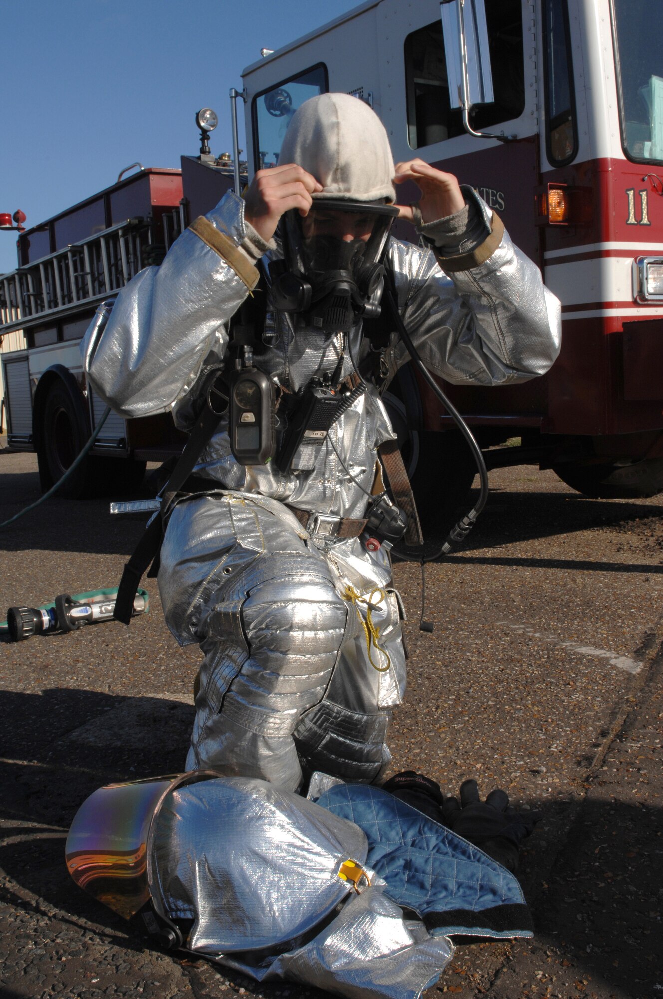 ROYAL AIR FORCE LAKENHEATH, England -- Airman 1st Class Christopher Hatch, 48th Civil Engineer Squadron firefighter, puts on protective equipment during an emergency response and mass casualty exercise, June 8, 2011.  Airmen from the 48th Fighter Wing responded to the incident after a simulated fuel line ruptured, spilling more than 15,000 gallons of jet fuel and causing a collision between a bus, a privately owned vehicle and a group of Airmen participating in physical training.  The purpose of the exercise was to validate and evaluate multiple procedures when responding to such a scenario.  (U.S. Air Force photo /Tech. Sgt. Lee A. Osberry Jr.)