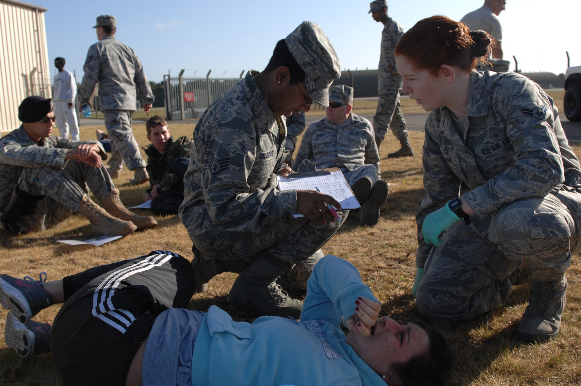 ROYAL AIR FORCE LAKENHEATH, England -- Staff Sgt. Tina Celestine, 48th Aerospace Medicine Squadron, medical administrator and Airman 1st Class Molly Ryan, 48th AMDS medical technician, take down information and care for vicitims during an emergency response and mass casualty exercise at Royal Air Force Lakenheath, England, June 8, 2011.  Airmen from the 48th Fighter Wing responded to the incident after a simulated fuel line ruptured, spilling more than 15,000 gallons of jet fuel and causing a collision between a bus, a privately owned vehicle and a group of Airmen participating in physical training.  The purpose of the exercise was to validate and evaluate multiple procedures when responding to such a scenario.  (U.S. Air Force photo /Tech. Sgt. Lee A. Osberry Jr.)