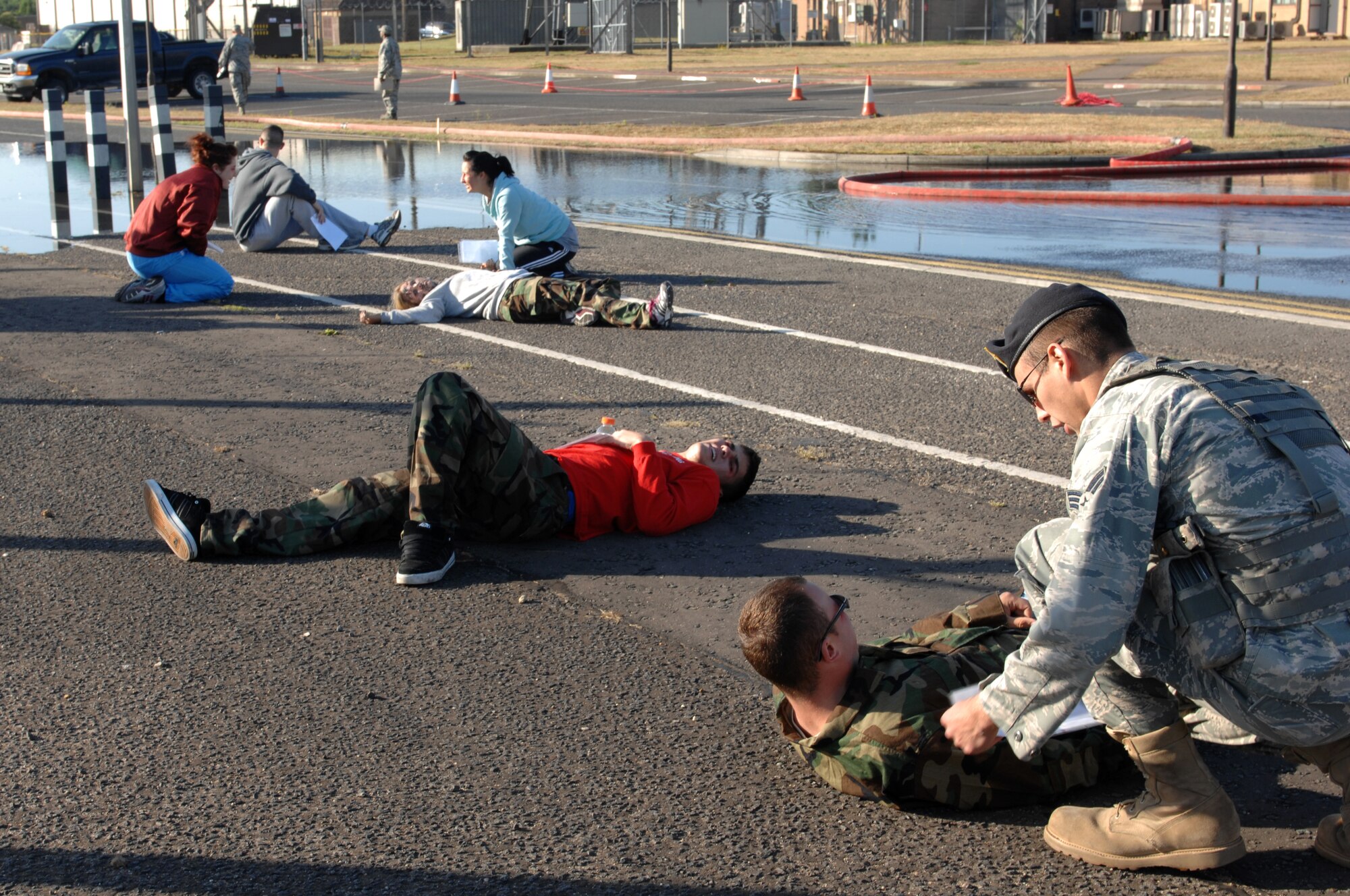 ROYAL AIR FORCE LAKENHEATH, England -- Senior Airman Patrick Whaley, 48th Security Forces Squadron patrolman, checks on a vicitim during an emergency response and mass casualty exercise June 8, 2011.  Airmen from the 48th Fighter Wing responded to the incident after a simulated fuel line ruptured, spilling more than 15,000 gallons of jet fuel and causing a collision between a bus, a privately owned vehicle and a group of Airmen participating in physical training.  The purpose of the exercise was to validate and evaluate multiple procedures when responding to such a scenario.  (U.S. Air Force photo /Tech. Sgt. Lee A. Osberry Jr.)