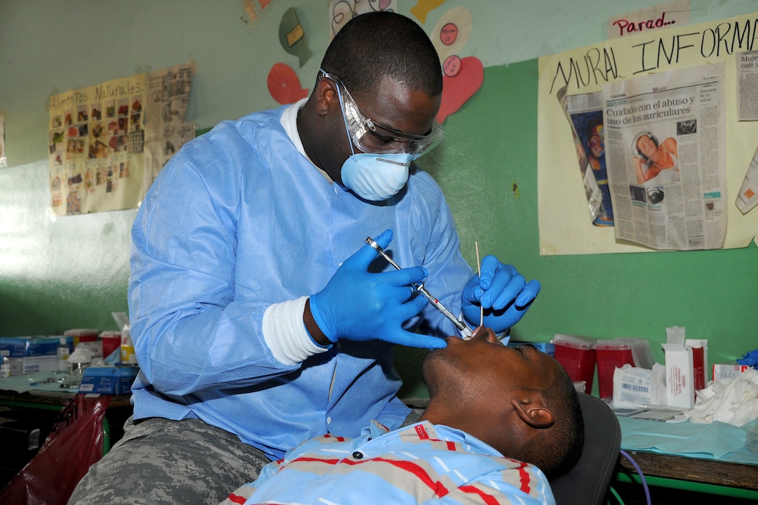 U.S. Army Maj. (Dr.) Michael Cole injects a numbing solution into a ...