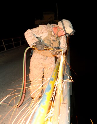 Cpl. Christopher L. Monson, from Blackfoot, Idaho, an automated maintenance technician with 7th Engineer Support Battalion, 2nd Marine Logistics Group (Forward), uses a gas torch to cut off the rails of a bridge in the Gamsir district, Helmand province, Afghanistan, June 16, 2011.  The Marines placed a bridge over the Darvishan Bridge as a temporary fix to allow Afghan contractors to repair it without stopping traffic in the area.  This project will directly benefit the Marines of 1st Battalion, 3rd Marine Regiment, 2nd Marine Division (Fwd.) who are currently operating in the district in support of the International Security Assistance Force as well as the local population.