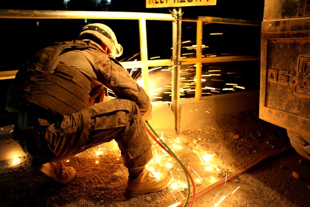 Cpl. Christopher L. Monson, from Blackfoot, Idaho, an automated maintenance technician with 7th Engineer Support Battalion, 2nd Marine Logistics Group (Forward), uses a gas torch to cut off the rails of a bridge in the Gamsir district, Helmand province, Afghanistan, June 16, 2011.  The Marines placed a bridge over the Darvishan Bridge as a temporary fix to allow Afghan contractors to repair it without stopping traffic in the area.  This project will directly benefit the Marines of 1st Battalion, 3rd Marine Regiment, 2nd Marine Division (Fwd.) who are currently operating in the district in support of the International Security Assistance Force as well as the local population.