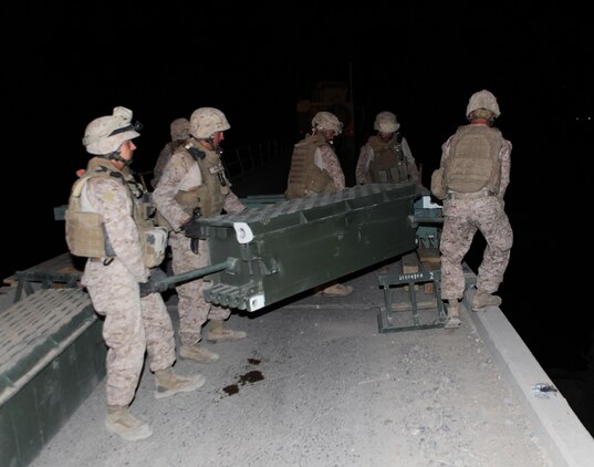 Marines with 7th Engineer Support Battalion, 2nd Marine Logistics Group (Forward) assemble a temporary bridge over the Darvishan Bridge in the Gamsir district, Helmand province, Afghanistan, June 16, 2011.  The Marines conducted the operation as a temporary fix to allow Afghan contractors to repair the structure without stopping traffic in the area.  This project will directly benefit the Marines of 1st Battalion, 3rd Marine Regiment, 2nd Marine Division (Fwd.) who are currently operating in the district in support of the International Security Assistance Force as well as the local population.