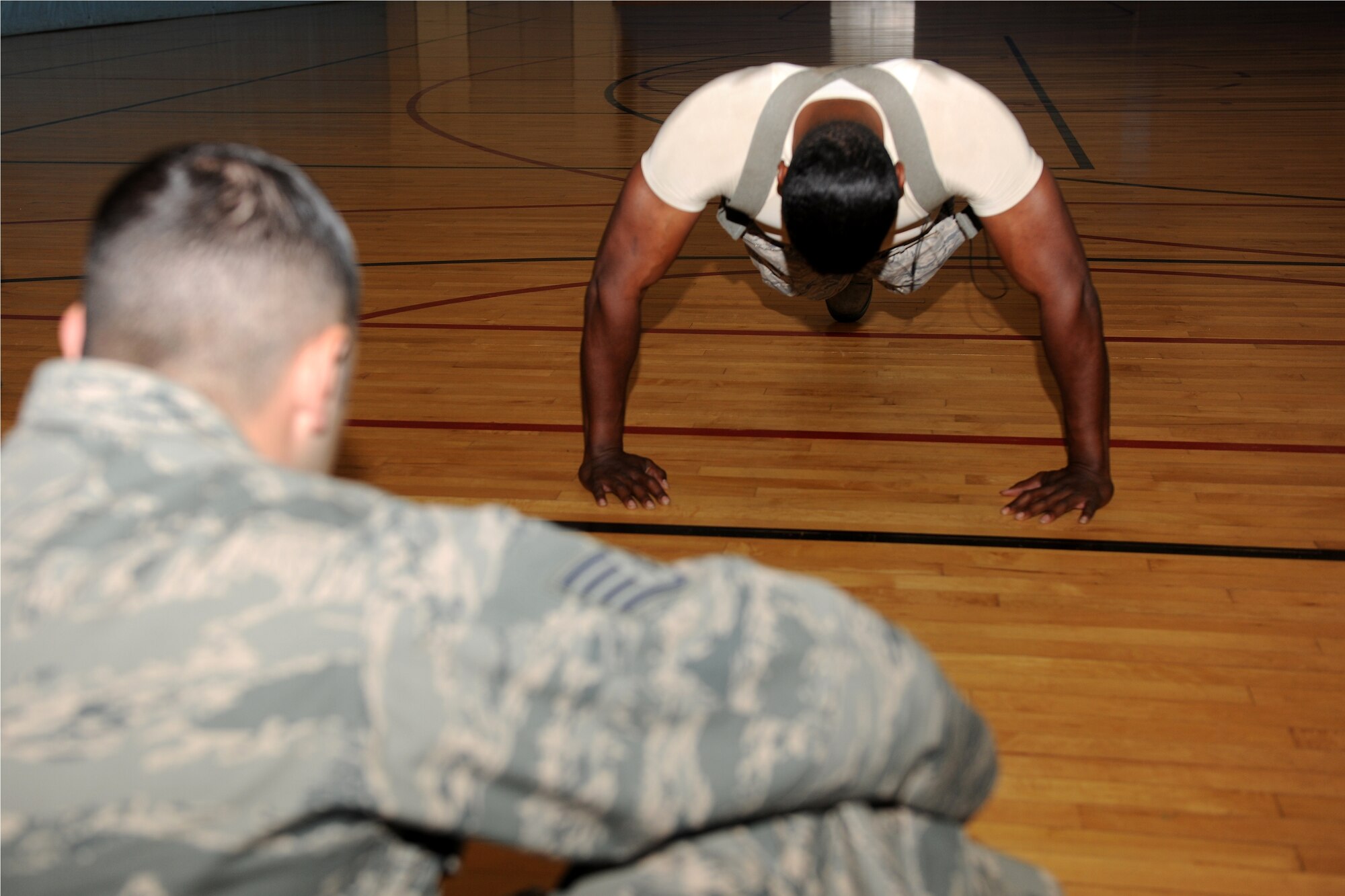 KUNSAN AIR BASE, Republic of Korea -- Staff Sgt. Israel Revuelta, 8th Force Support Squadron assistant guest services manager at the Wolf Pack Lodge, watches as Senior Airman Samuale Bailey, 8th Communications Squadron cable antenna maintenance, participates in the First Sergeant’s Push-Up Challenge at the Fitness and Sports Center here June 15. Participants had an alloted time of 10 minutes to do as many Air Force style push-ups as possible. (U.S. Air Force photo/Senior Airman Ciara Wymbs)