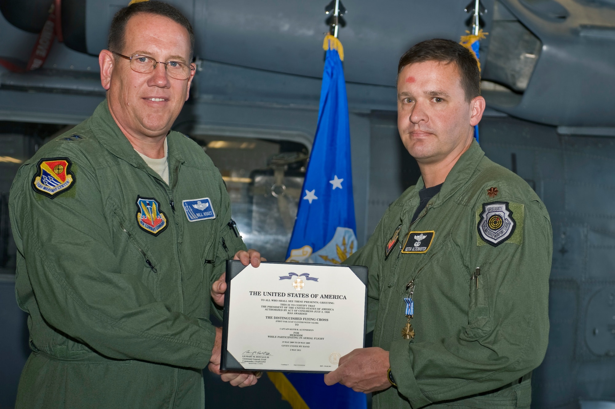 NELLIS AIR FORCE BASE, Nev.--U.S. Air Force Maj. Gen. James Hyatt presents the Distinguished Flying Cross with valor to Maj. Keith Altenhofen, 561st Joint Tactics Squadron instructor pilot, June 15, 2011, at the 763rd Maintenance hangar. Major Altenhofen received the medal for repeatedly placing himself in the line of enemy fire to rescue injured soldiers May 19, 2009, in Afghanistan. (U.S. Air Force photo by Airman 1st Class Matthew Lancaster)