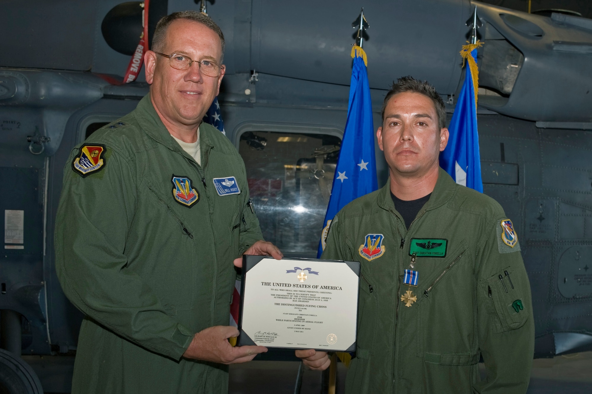 NELLIS AIR FORCE BASE, Nev.--U.S. Air Force Maj. Gen. James Hyatt presents the Distinguished Flying Cross with valor to Tech. Sgt. Christian Corella, 88th Test and Evaluation Squadron aerial gunner, June 15, 2011, at the 763rd Maintenance hangar. Sergeant Corella received the award for placing himself directly in the line of danger and returning enemy fire while evacuating an Afghan national and 40 U.S. Special Forces soldiers May 19, 2009, in Afghanistan. (U.S. Air Force photo by Airman 1st Class Matthew Lancaster)