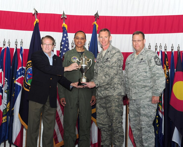 MINOT AIR FORCE BASE, N.D. -- Mark Theisen, U.S. STRATCOM Consultation Committee representative and Vice Adm. Cecil Haney, U.S. Strategic Command deputy commander, present the Omaha Trophy to Col. James Dawkins, 5th Bomb Wing commander and Chief Master Sgt. Kent Smith, 5th Bomb Wing command chief here June 15. Team Minot received recognition for their hard work and dedication by receiving the Omaha Trophy for the best intercontinental ballistic missile and best strategic aircraft operations. The Omaha Trophy is awarded annually to military units demonstrating the highest performance standards in U.S. STRATCOM. (U.S. Air Force photo/Senior Airman Michael J. Veloz)