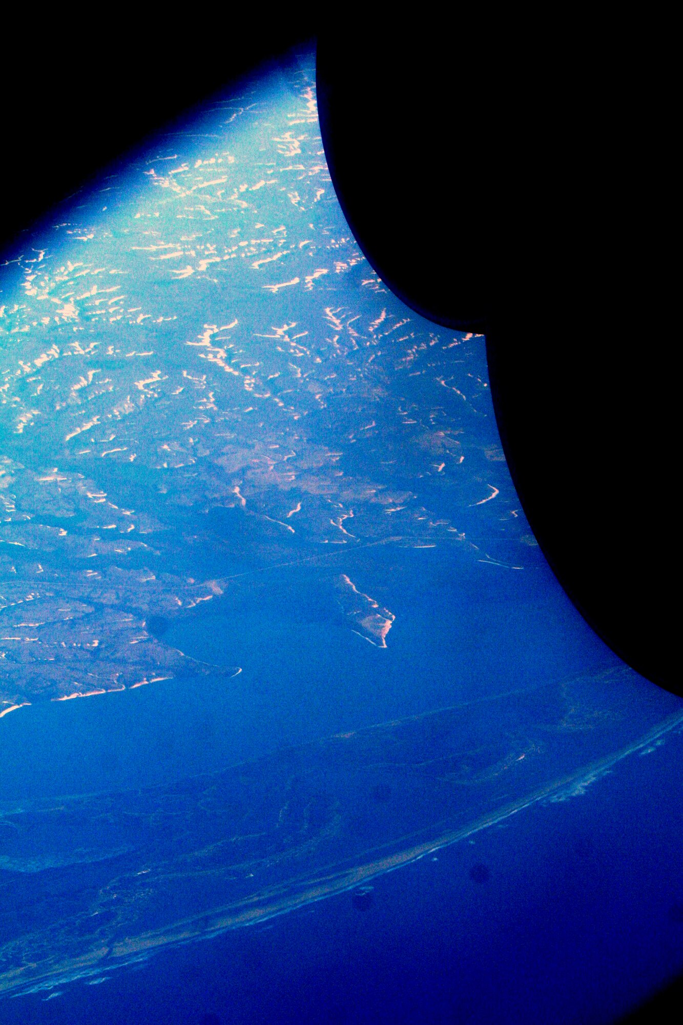 Ice-covered areas are seen from above the Arctic Circle at the tip of the Asian continent from the window of a C-5M Super Galaxy on a mission from Dover Air Force Base, Del., on June 5, 2011. The C-5M's mission was to complete the first Arctic overflight from Dover AFB to Bagram Airfield, Afghanistan. The plane successfully landed at Bagram just over 15 hours later on June 6, 2011. (U.S. Air Force Photo/Master Sgt. Scott T. Sturkol)