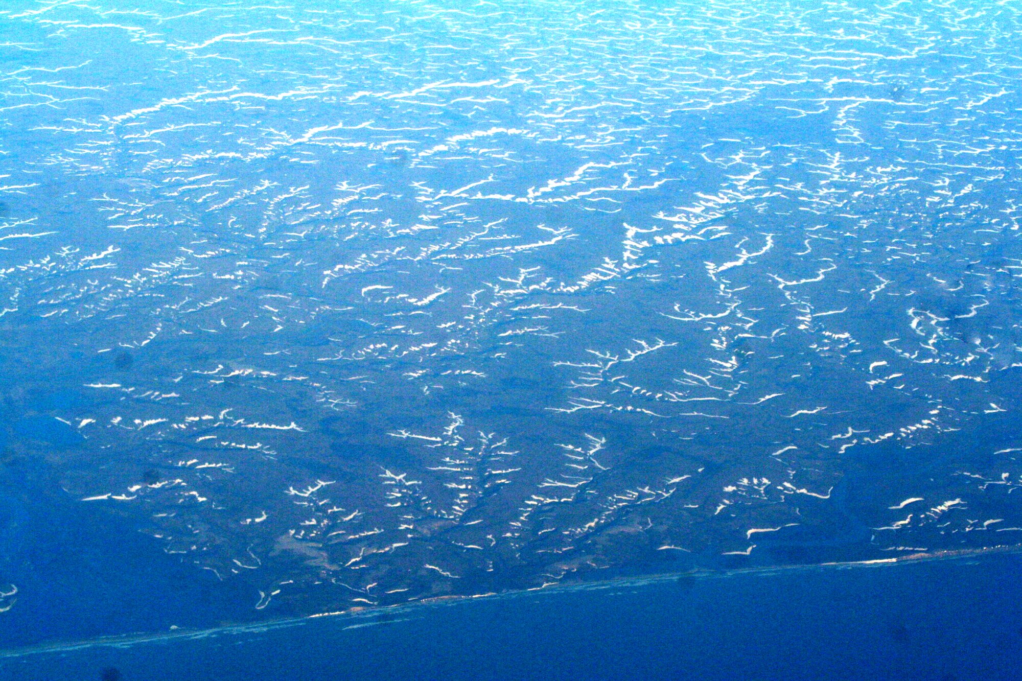 Ice-covered areas are seen from above the Arctic Circle at the tip of the Asian continent from the window of a C-5M Super Galaxy on a mission from Dover Air Force Base, Del., on June 5, 2011. The C-5M's mission was to complete the first Arctic overflight from Dover AFB to Bagram Airfield, Afghanistan. The plane successfully landed at Bagram just over 15 hours later on June 6, 2011. (U.S. Air Force Photo/Master Sgt. Scott T. Sturkol)