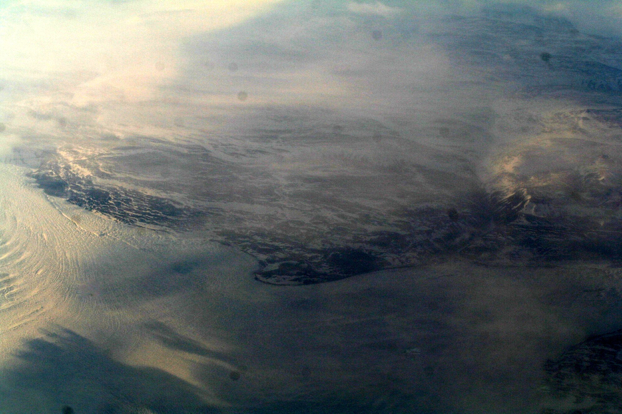 Ice-covered areas are seen from above the Arctic Circle from the window of a C-5M Super Galaxy on a  mission from Dover Air Force Base, Del., on June 5, 2011. The C-5M's mission was to complete the first Arctic overflight from Dover AFB to Bagram Airfield, Afghanistan. The plane successfully landed at Bagram just over 15 hours later on June 6, 2011. (U.S. Air Force Photo/Master Sgt. Scott T. Sturkol)