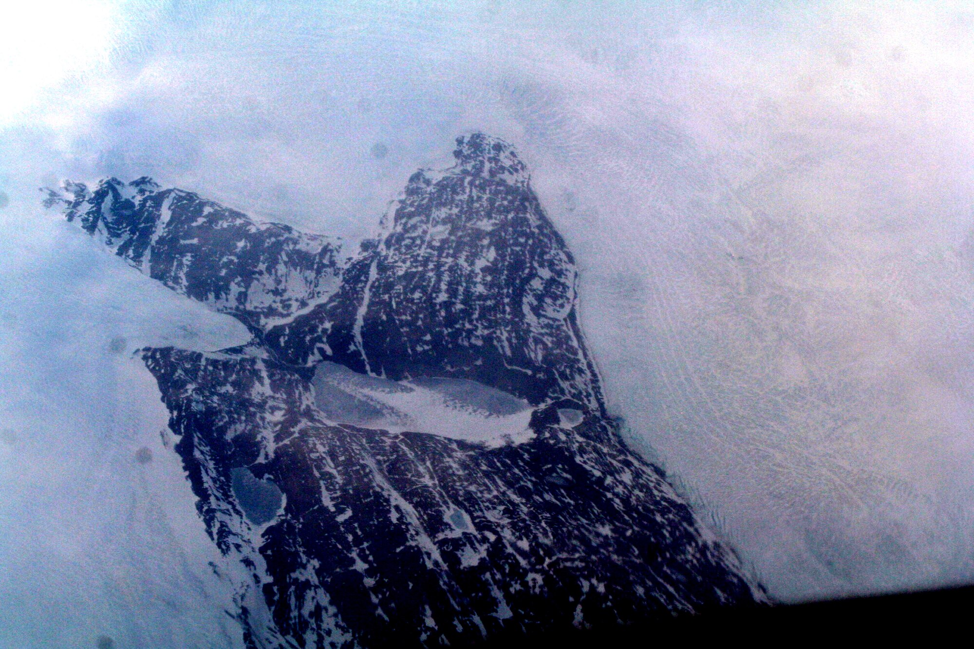 Ice-covered areas are seen from above the Arctic Circle from the window of a C-5M Super Galaxy on a  mission from Dover Air Force Base, Del., on June 5, 2011. The C-5M's mission was to complete the first Arctic overflight from Dover AFB to Bagram Airfield, Afghanistan. The plane successfully landed at Bagram just over 15 hours later on June 6, 2011. (U.S. Air Force Photo/Master Sgt. Scott T. Sturkol)
