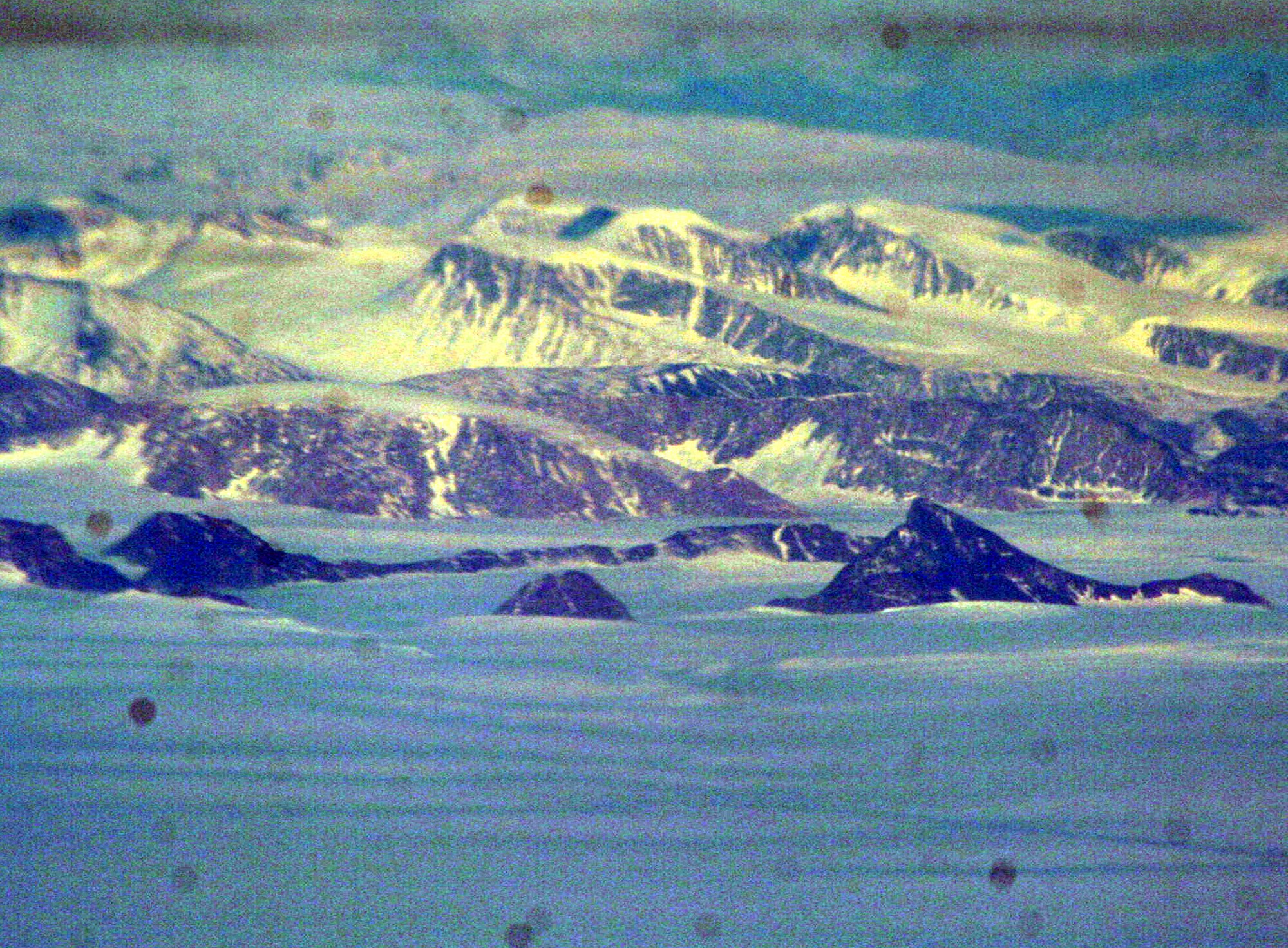 Ice-covered areas are seen from above the Arctic Circle from the window of a C-5M Super Galaxy on a  mission from Dover Air Force Base, Del., on June 5, 2011. The C-5M's mission was to complete the first Arctic overflight from Dover AFB to Bagram Airfield, Afghanistan. The plane successfully landed at Bagram just over 15 hours later on June 6, 2011. (U.S. Air Force Photo/Master Sgt. Scott T. Sturkol)