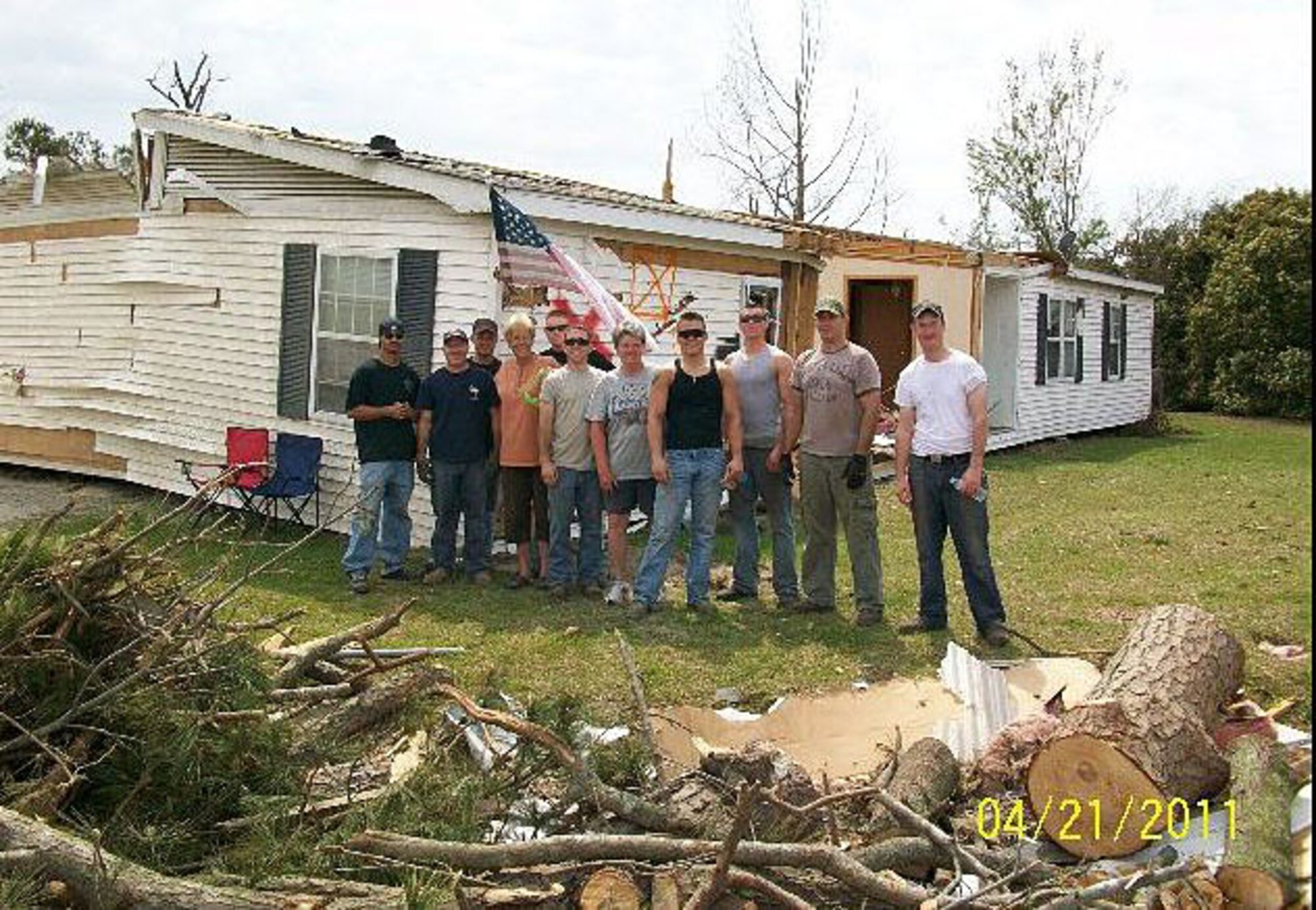 Airmen from the 334th Aircraft Maintenance Squadron pose for a photo while assisting a woman to clean her yard after a tornado tore through Snow Hill, N.C. April 16, 2011. (Courtesy photo)