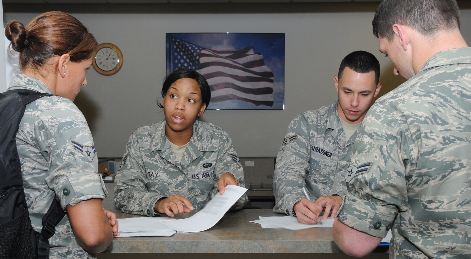 In the background, Senior Airman Chamira May, left, and Airman 1st Class Jason Strasner, 81st Force Support Squadron, assist Airman 1st Class Amanda Mitchell, left, 338th Training Squadron student, and Airman 1st Class Aleander Edwards, 334th TRS student, with their outprocessing papers at the student personnel center.  (U.S. Air Force photo by Kemberly Groue)