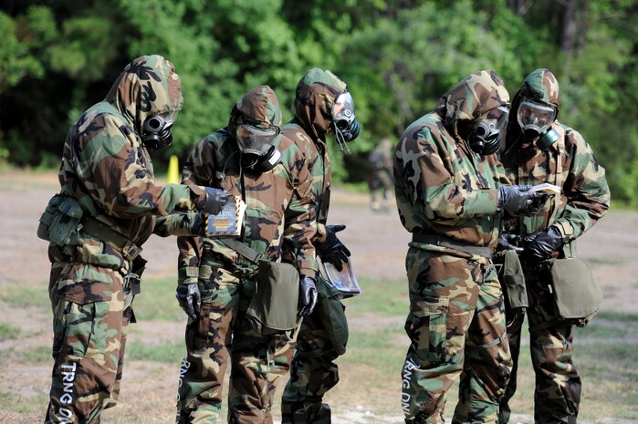 Airmen look through their Airmen's manuals while doing a sweep for unexploded ordinance during Chemical Biological Radiological Nuclear and high yield Explosive Training at Joint Base Charleston June 9. The CBRNE course teaches Airmen how to survive and operate in hazardous environments.  (U.S. Air Force photo/ Staff Sgt. Nicole Mickle)