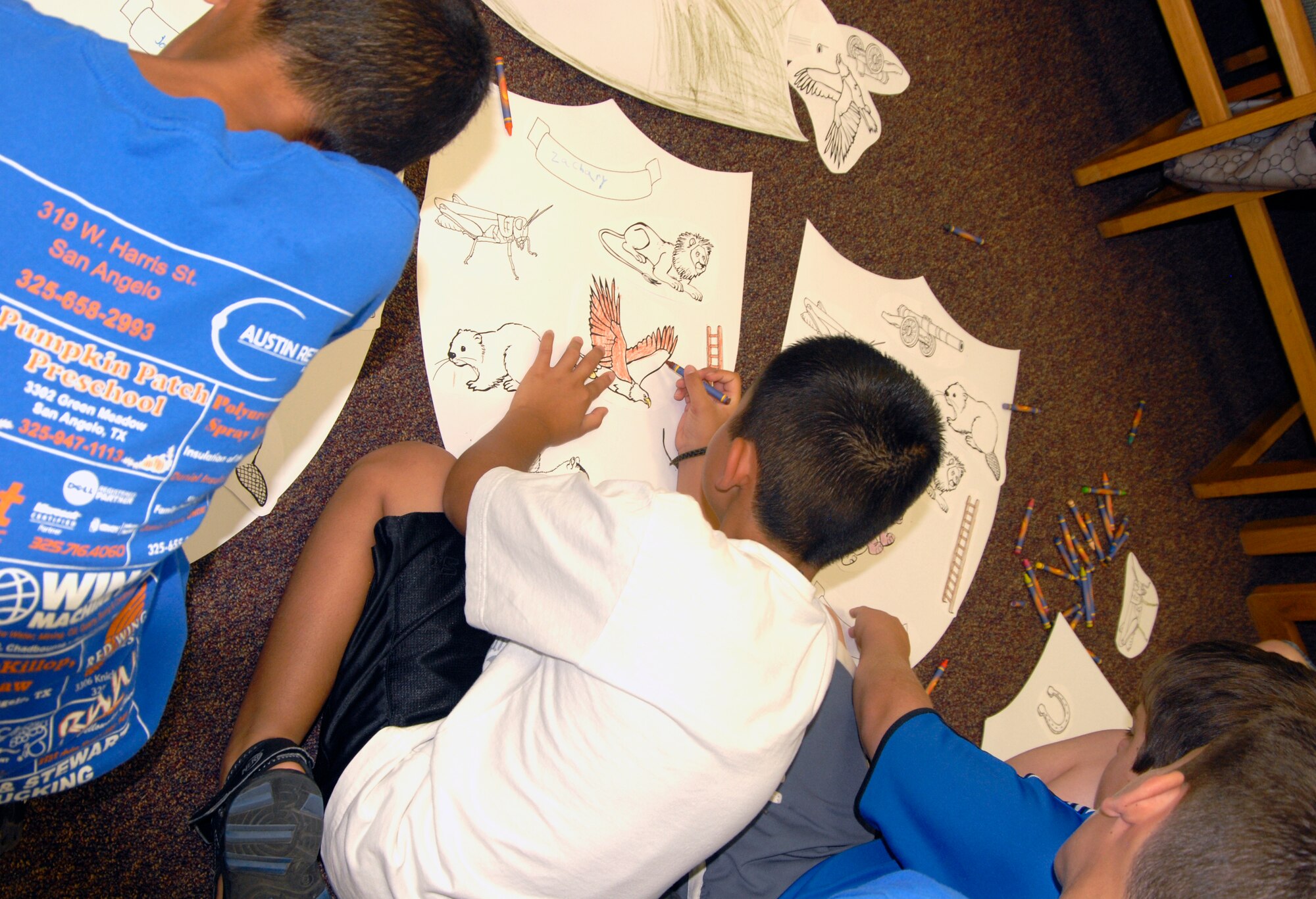 GOODFELLOW AIR FORCE BASE, Texas – Some youths in the summer reading program here decorate their own shield during this week’s meeting June 15 at the library.  More than 100 youths are signed up for this year’s program, A Midsummer Knight’s Read, where youths learn about the Renaissance Era. (U.S. Air Force photo/Connie Hempel)