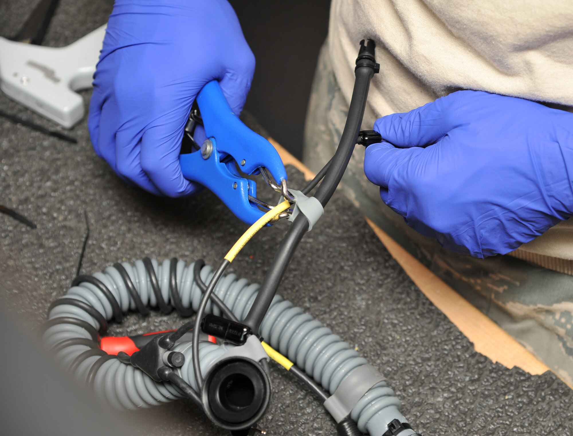 SEYMOUR JONHSON AIR FORCE BASE, N.C.- Staff Sgt. Eric Pancia uses a elastrator to add communication cord to an oxygen hose during an inspection here, June 14, 2011. The communication cord allows aircrew members to speak through a microphone to other pilots, air traffic controllers and the other aircrew member. Sergeant Pancia is a 4th Operations Support Squadron aircrew flight equipment craftsmen and a native of Buffalo, N.Y. (U.S. Air Force photo by Senior Airman Whitney Lambert/RELEASED)