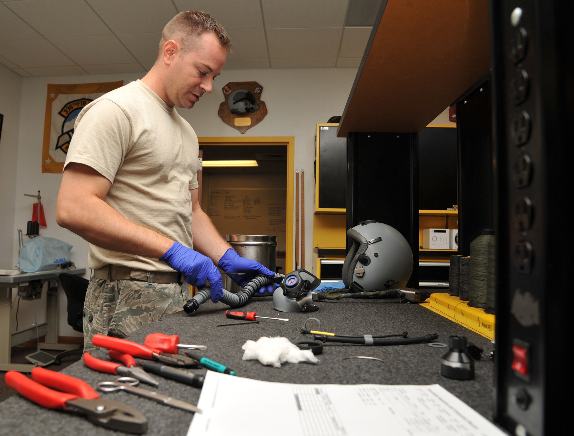 SEYMOUR JONHSON AIR FORCE BASE, N.C.- Staff Sgt. Eric Pancia looks over aircrew equipment before putting it back together during an inspection here, June 14, 2011. Every component attached to a helmet is removed and reviewed during inspections. Sergeant Pancia is a 4th Operations Support Squadron aircrew flight equipment craftsmen and a native Buffalo, N.Y. (U.S. Air Force photo by Senior Airman Whitney Lambert/RELEASED)