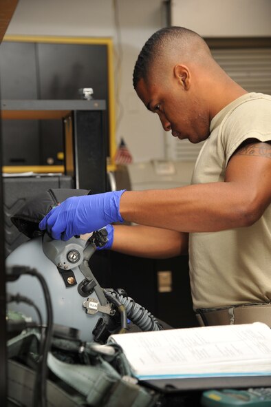 SEYMOUR JONHSON AIR FORCE BASE, N.C.- Airman 1st Class Kendric Skinner adds a joint helmet mounted cueing system (jhmcs) to a helmet during an inspection here, June 14, 2011. A JHMCS projects a vision of weapons and sensors to a target in the helmet visor. Airman Skinner is a 4th Operations Support Squadron aircrew flight equipment journeyman and a native of Jacksonville. (U.S. Air Force photo by Senior Airman Whitney Lambert/RELEASED)