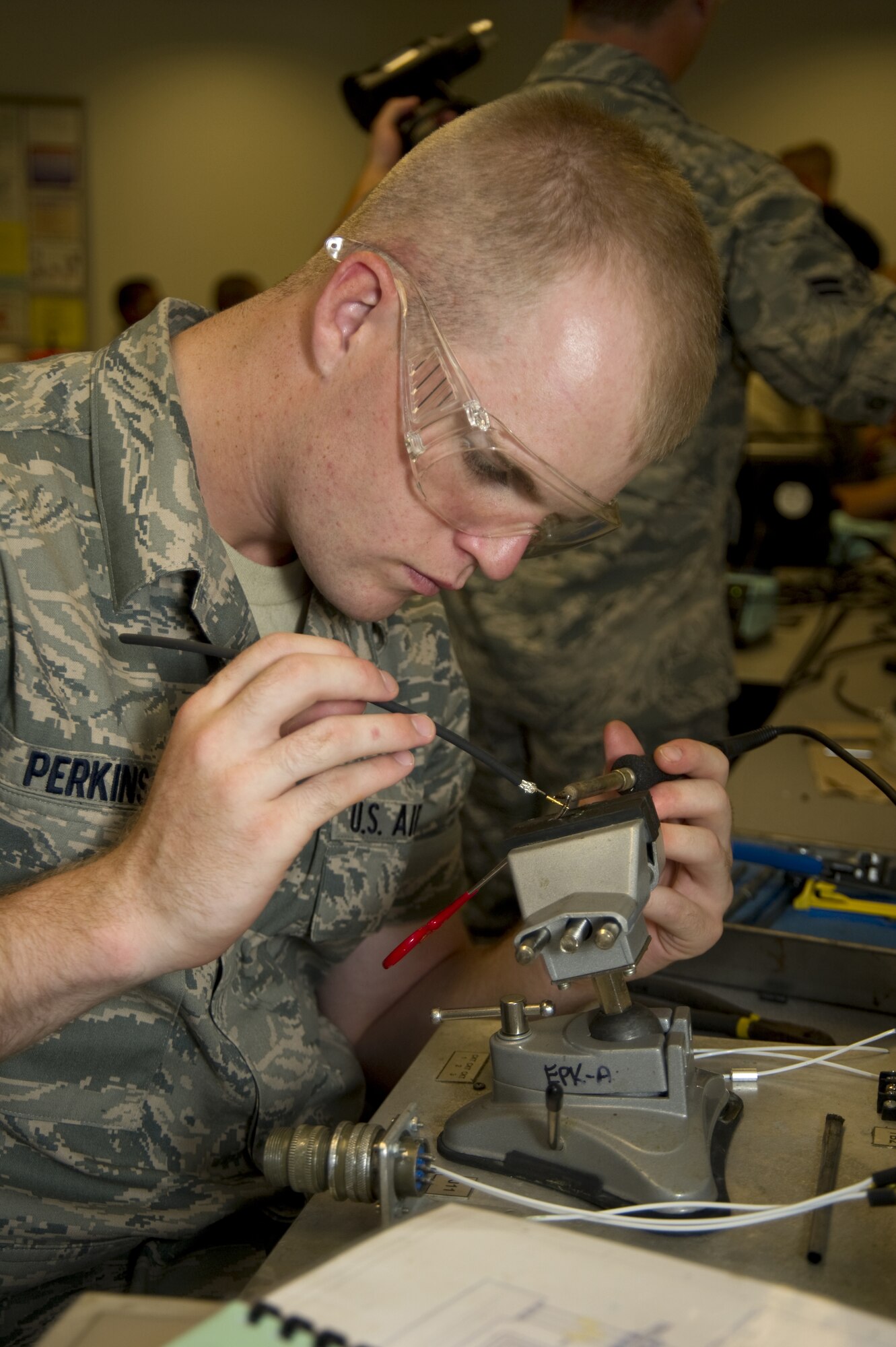 Airman Basic John Perkins works on his soldering skills Monday in the connector/wiring
maintenance block of the electronic principles course in the 332nd Training Squadron.  The unit is “standing down” Friday in preparation for deactivation once approval is given from Air Staff. In this management realignment, current 332nd TRS courses are divided between the 333rd TRS and 335th TRS.  (U.S. Air Force photo by Adam Bond)