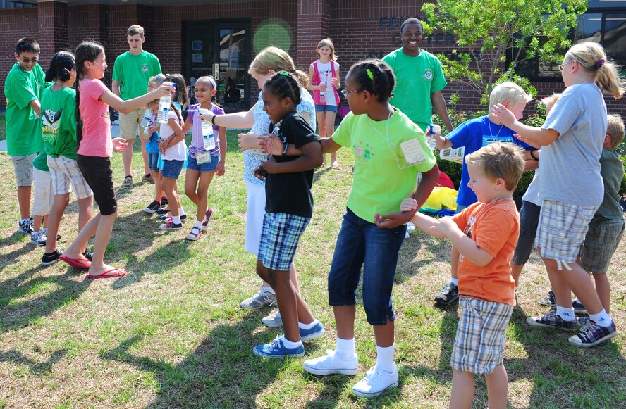 Children of the Pandamania Vacation Bible School work together during a game at Moody Air Force Base, Ga., June 14, 2011. The purpose of the game was to build trust by listening to the teammate with open eyes in order to move to desired areas of the yard. (U.S. Air Force Senior Airman Stephanie Mancha/Released)