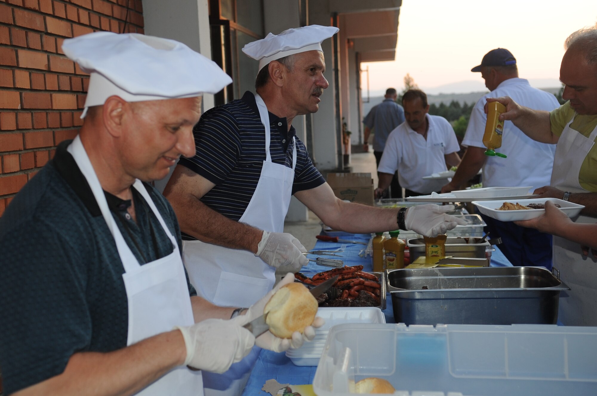 CAMP PEPELISHTE, Macedonia ? Col. (Dr.) Charles Tedder, 2011 Medical Training Exercise in Central and Eastern Europe co-director and 3rd Air Force command surgeon and Col. (Dr.) Andreja Naumovski, Macedonian co-director of MEDCEUR 11 serve for participants during an appreciation dinner June 13. An annual Chairman of the Joint Chiefs of Staff-sponsored regional and multilateral exercise, MEDCEUR is designed to provide medical training and operational experience in a deployed environment for U.S. and partner nations. The countries participating in this year's MEDCEUR are Macedonia, Montenegro, Bosnia and Herzegovina, Serbia, Slovenia and Norway. (U.S. Air Force photo/Staff Sgt. Nadine Y. Barclay)