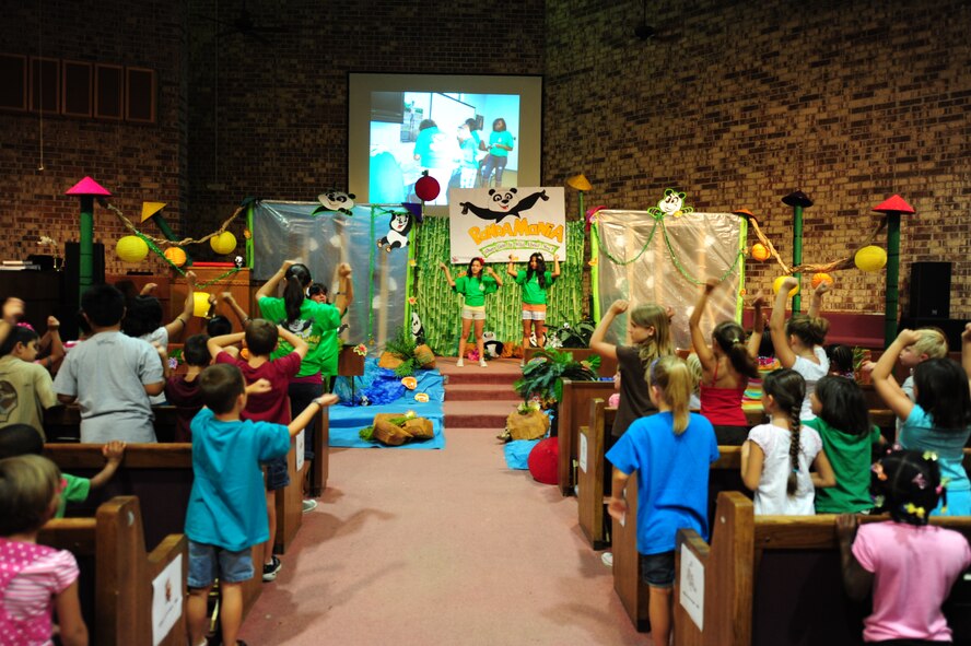 Children attending the Pandamania Vacation Bible School dance and sing in the chapel before transitioning to different classrooms at Moody Air Force Base, Ga., June 14, 2011. This year’s theme is Pandamania “Gods wild about you”; the children learned about life lessons and becoming better people. (U.S. Air Force Senior Airman Stephanie Mancha/Released)   
