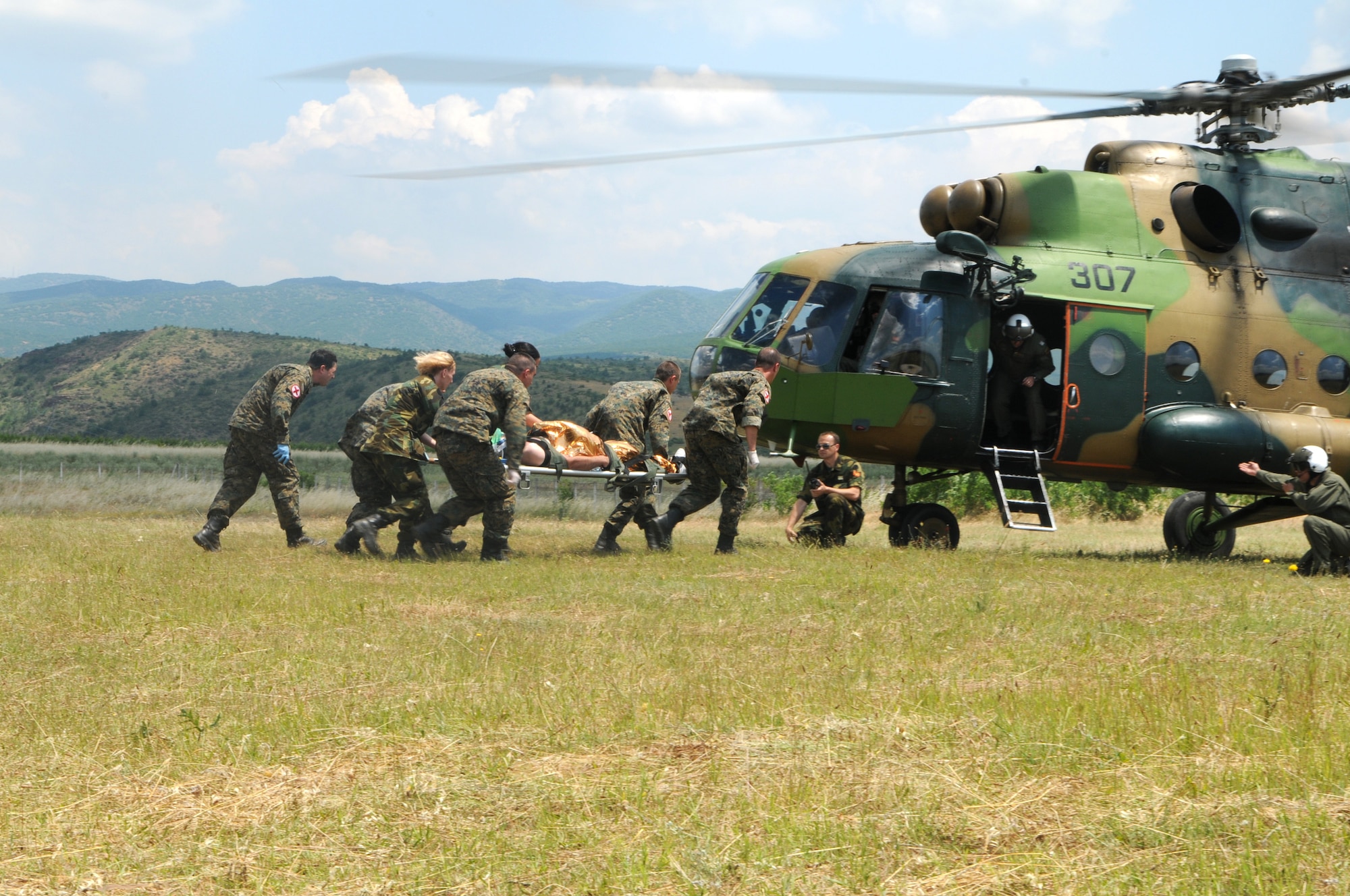 CAMP PEPELISHTE, Macedonia -- Medical personnel carry a litter with a simulated patient to an awaiting Macedonian MI-17 for medical evacuation during a visit by distinguished multinational guests to the 2011 Medical Training Exercise in Central and Eastern Europe hands-on training exercise June 13. An annual Chairman of the Joint Chiefs of Staff-sponsored regional and multilateral exercise, MEDCEUR is designed to provide medical training and operational experience in a deployed environment for U.S. and partner nations. The countries participating in this year's MEDCEUR are Macedonia, Montenegro, Bosnia and Herzegovina, Serbia, Slovenia and Norway. (U.S. Air Force photo/Staff Sgt. Julius Delos Reyes)
