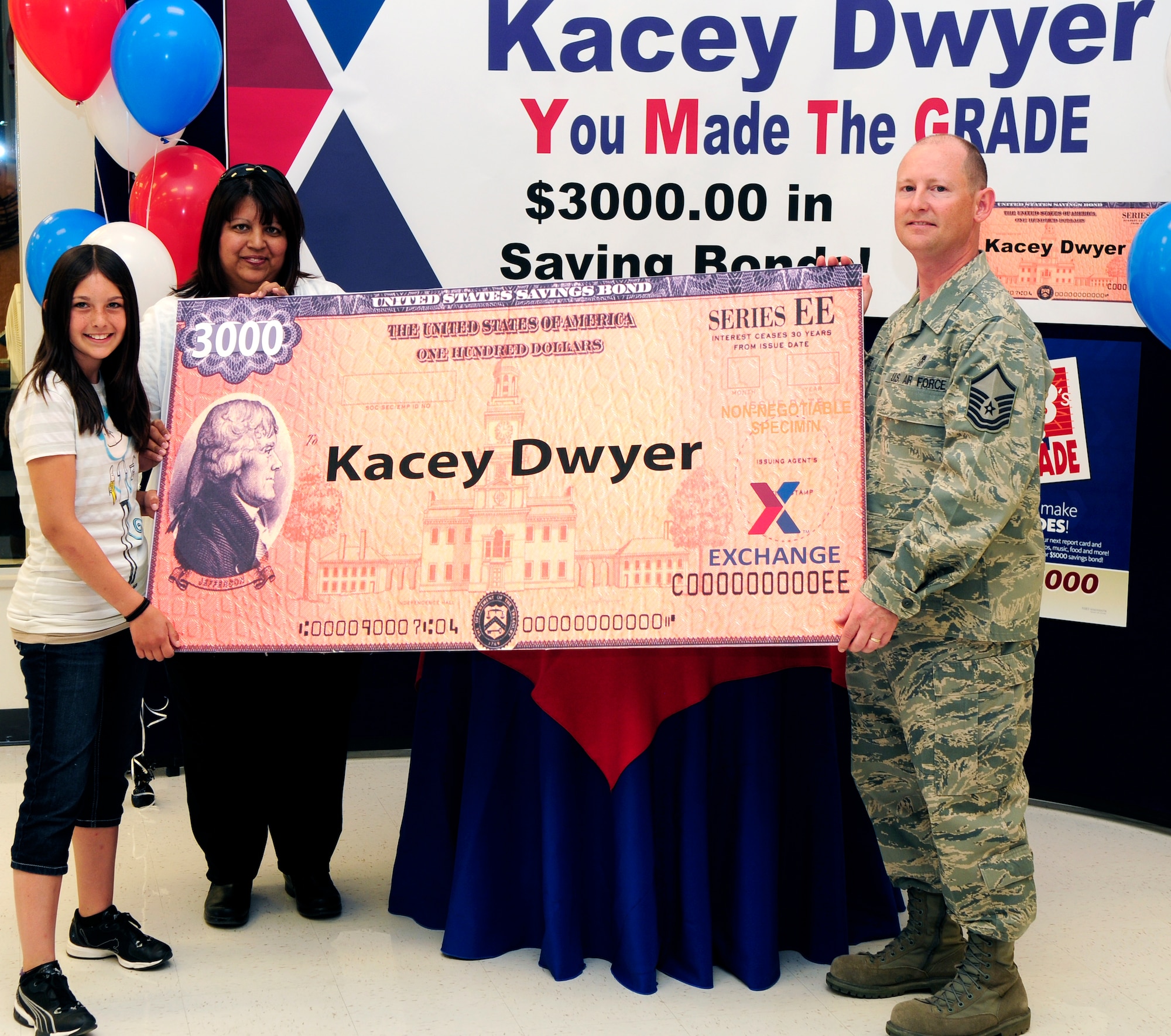 Army Air Force Exchange Service recognizes Kacey Dwyer as a "You Made the Grade" savings bond winner June 7, 2011, Eielson Air Force Base, Alaska.  As the second place winner of "You Made the Grade" drawing, the 11 year-old received a $3,000 in savings bonds as a reward to efforts in the classroom.  She is accompanied by her parents, Master Sgt. Daniel Dwyer assigned to the 354th Force Support Squadron and Monica Dwyer.  (U.S. Air Force photo/Airman 1st Class Yash Rojas)