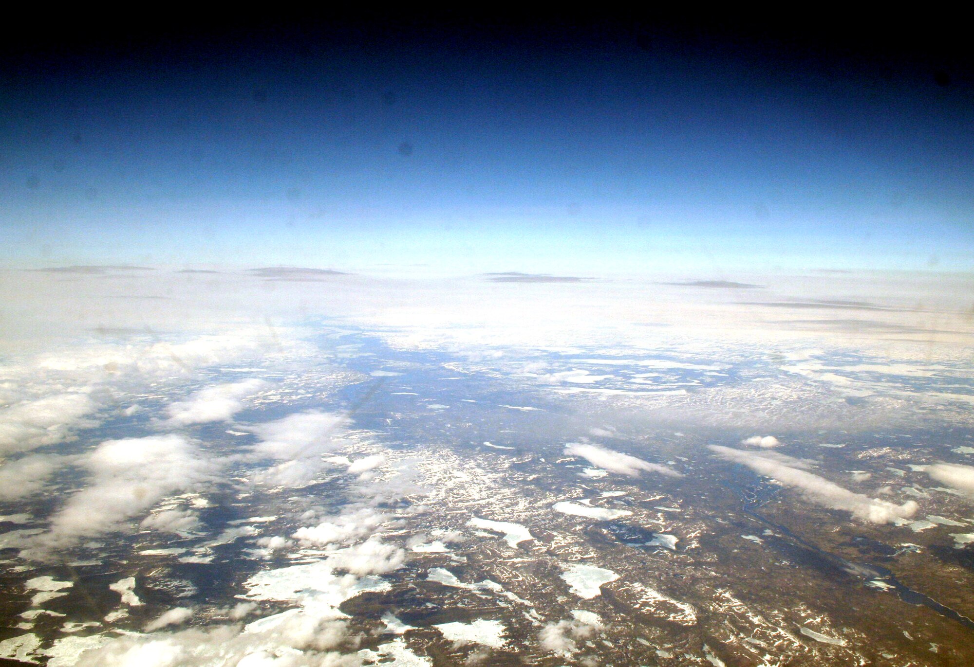 Ice-covered areas are seen from above the Arctic Circle from the window of a C-5M Super Galaxy on a  mission from Dover Air Force Base, Del., on June 5, 2011. The C-5M's mission was to complete the first Arctic overflight from Dover AFB to Bagram Airfield, Afghanistan. The plane successfully landed at Bagram just over 15 hours later on June 6, 2011. (U.S. Air Force Photo/Master Sgt. Scott T. Sturkol)