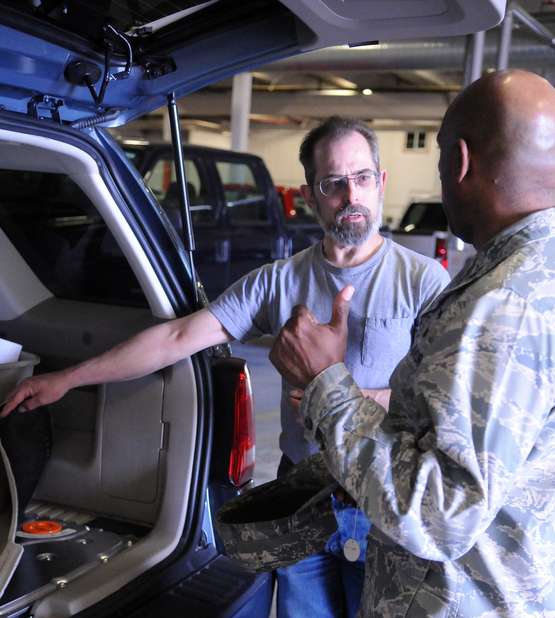 Mike Cordell, a 354th Logistics Readiness Squadron  vehicle operations vehicle repair technician, explains how the 2011 Ford Escape hybrid works using two different power sources to Col. Karlton Johnson June 3, 2011, Eielson Air Force Base, Alaska. The Escape is the first dry-lease hybrid car assigned to Eielson. Colonel Johnson is the 354th Mission Support Group commander.  (U.S. Air Force photo/Senior Airman Rachelle Coleman)