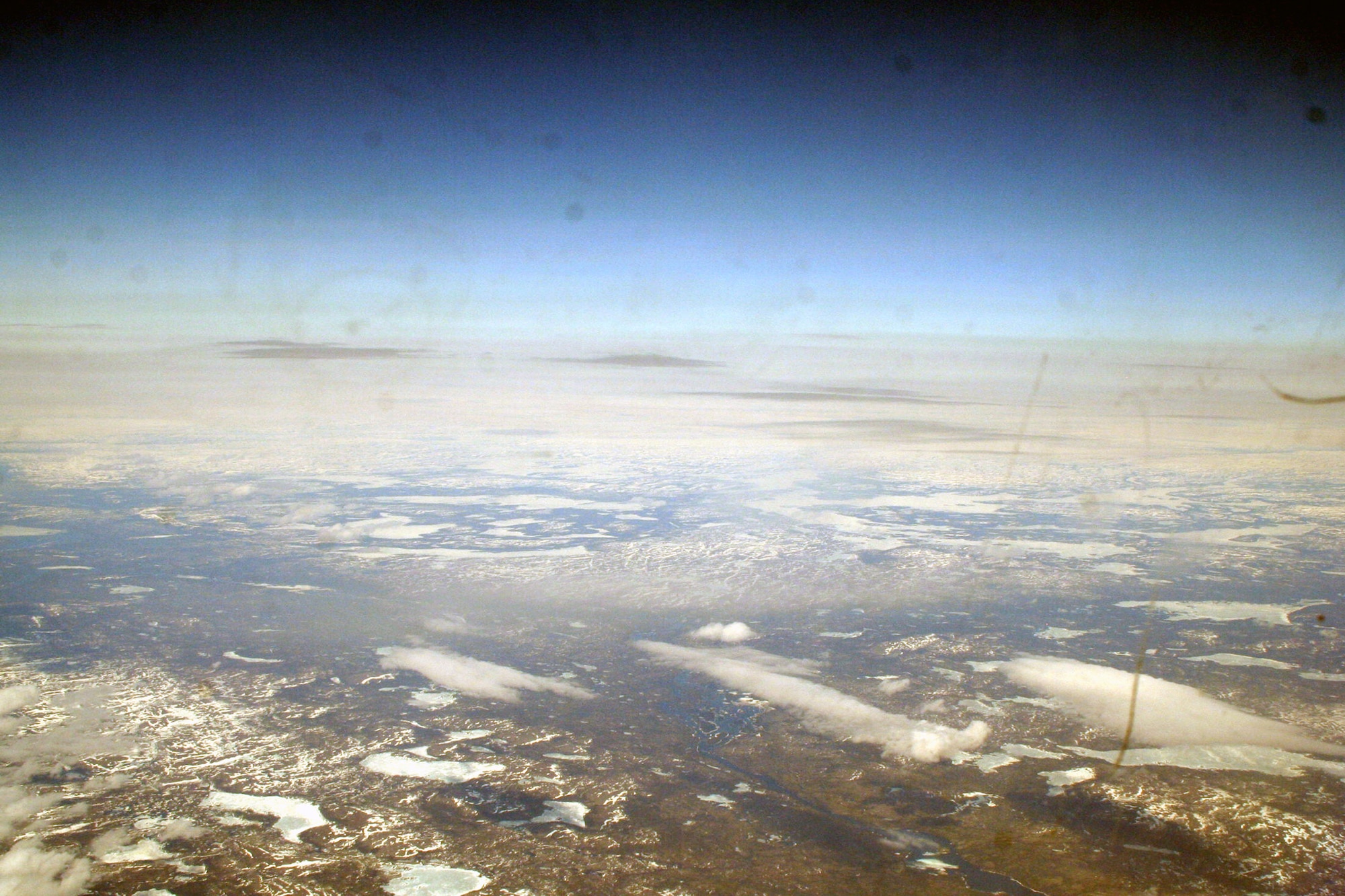 Ice-covered areas are seen from above the Arctic Circle from the window of a C-5M Super Galaxy on a  mission from Dover Air Force Base, Del., on June 5, 2011. The C-5M's mission was to complete the first Arctic overflight from Dover AFB to Bagram Airfield, Afghanistan. The plane successfully landed at Bagram just over 15 hours later on June 6, 2011. (U.S. Air Force Photo/Master Sgt. Scott T. Sturkol)
