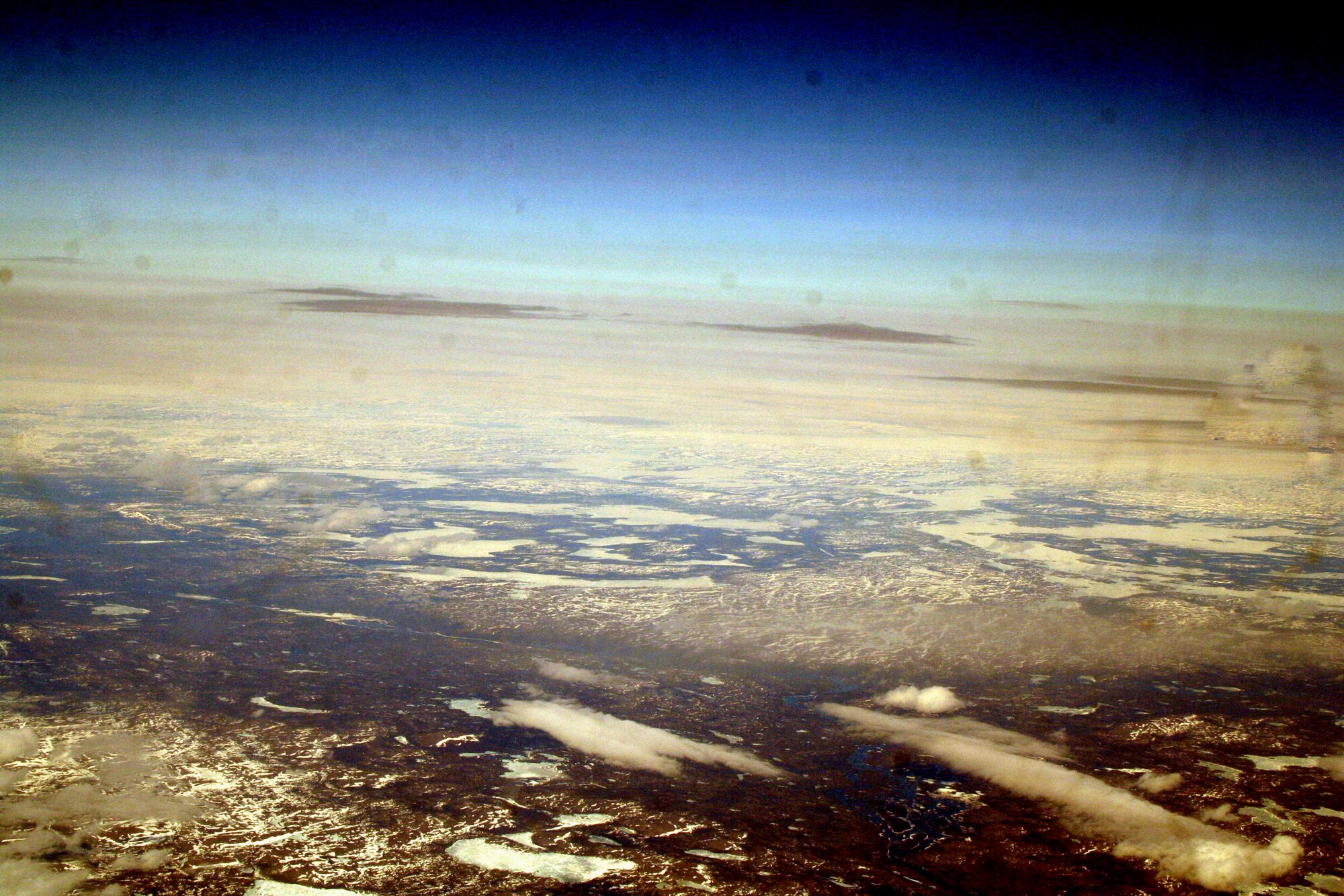 Ice-covered areas are seen from above the Arctic Circle from the window of a C-5M Super Galaxy on a  mission from Dover Air Force Base, Del., on June 5, 2011. The C-5M's mission was to complete the first Arctic overflight from Dover AFB to Bagram Airfield, Afghanistan. The plane successfully landed at Bagram just over 15 hours later on June 6, 2011. (U.S. Air Force Photo/Master Sgt. Scott T. Sturkol)