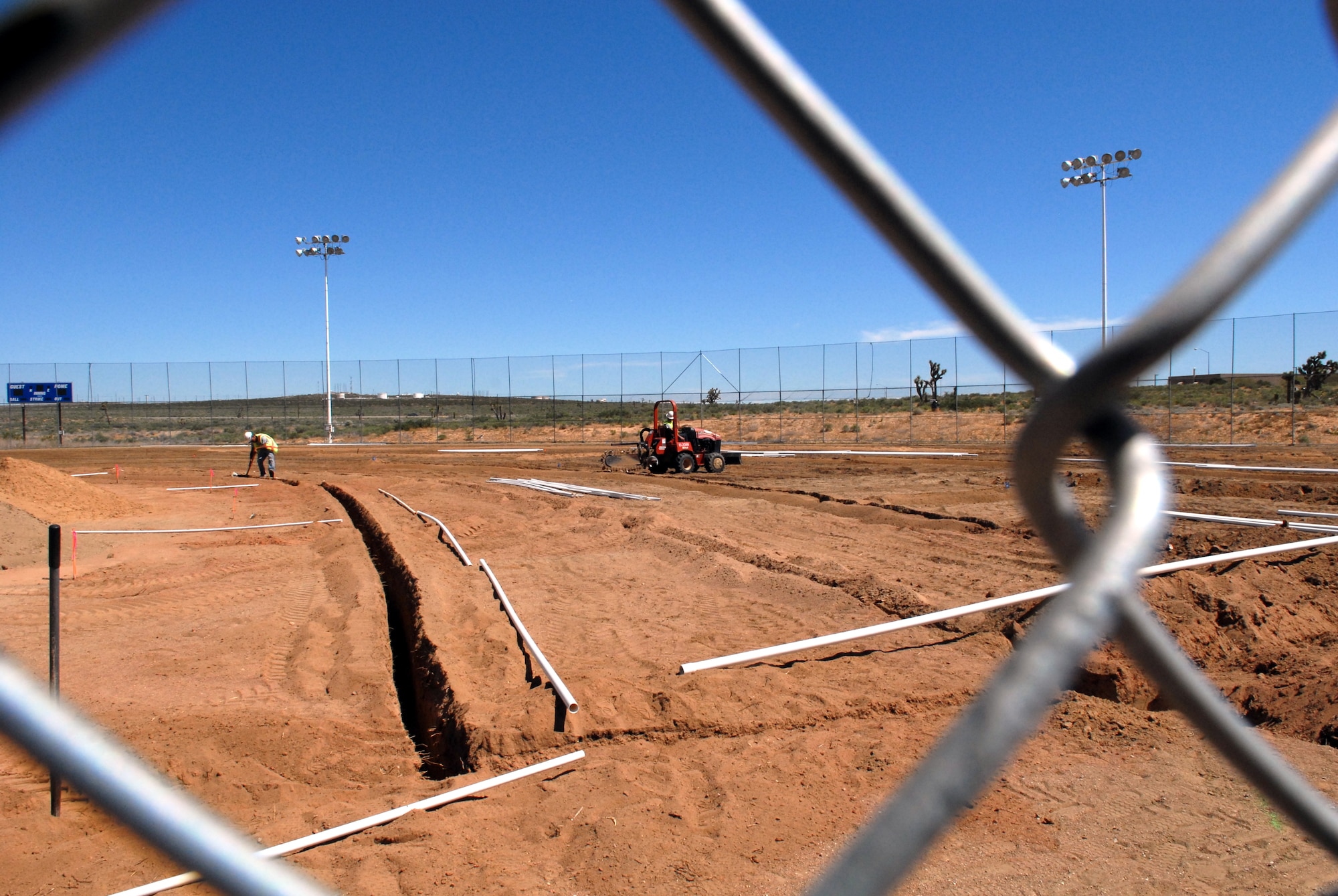 Leveling the playing field, a construction crew installs a new sprinkler system at the softball field behind the Rosburg Fitness Center. Construction on the field will also include laying new grass, infield dirt and erecting a sun shade over the bleachers along the first- and third-base lines. This is one of several ongoing projects aimed at improving base quality of life and expanding workout space. (Air Force photo by Kate Blais)