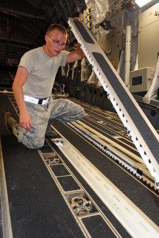 Senior Airman Frank Utter inspects the floor rollers of a C-17 aircraft for foreign object debris, loose hardware and cleanliness during Rodeo practice at Joint Base Charleston June 10. Airman Utter is assigned to the 437th Aircraft Maintenance Squadron and is a member of the 437th Airlift Wing 2011 Air Mobility Command Rodeo team. (U.S. Air Force photo/Tech. Sgt. Chrissy Best)
