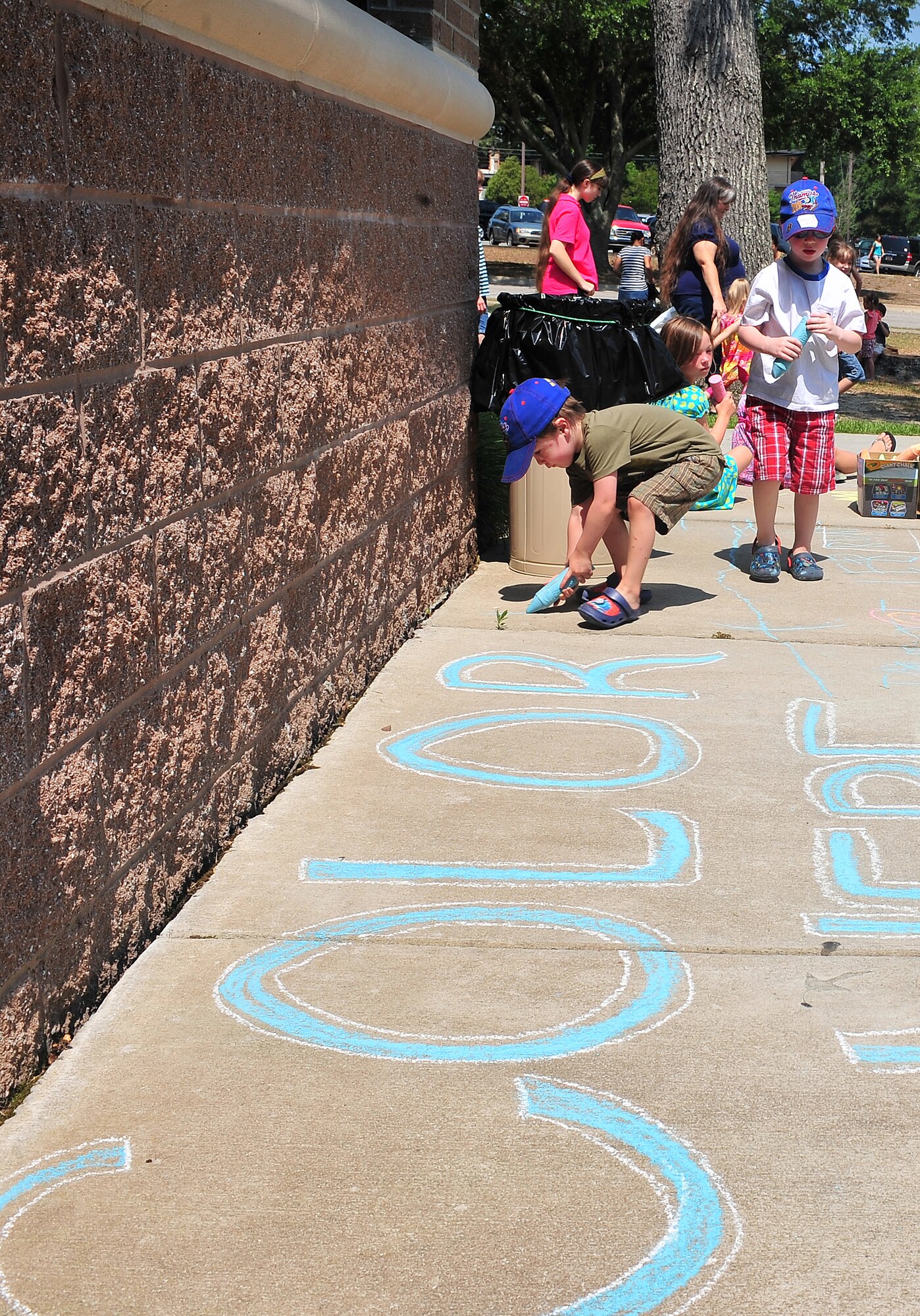 SHAW AIR FORCE BASE, S.C. -- Brothers Cameron and Joseph Marez, sons of Tech. Sgt. Leonard Marez, 20th Communications Squadron NCOIC of airfield systems and radar, color on the sidewalk at the McElveen Library here, June 13, 2011. The theme for the program this year is, 'A Midsummer Knight's Read.' (U.S. Air Force photo/ Airman 1st Class Ashley Gardner (Released).