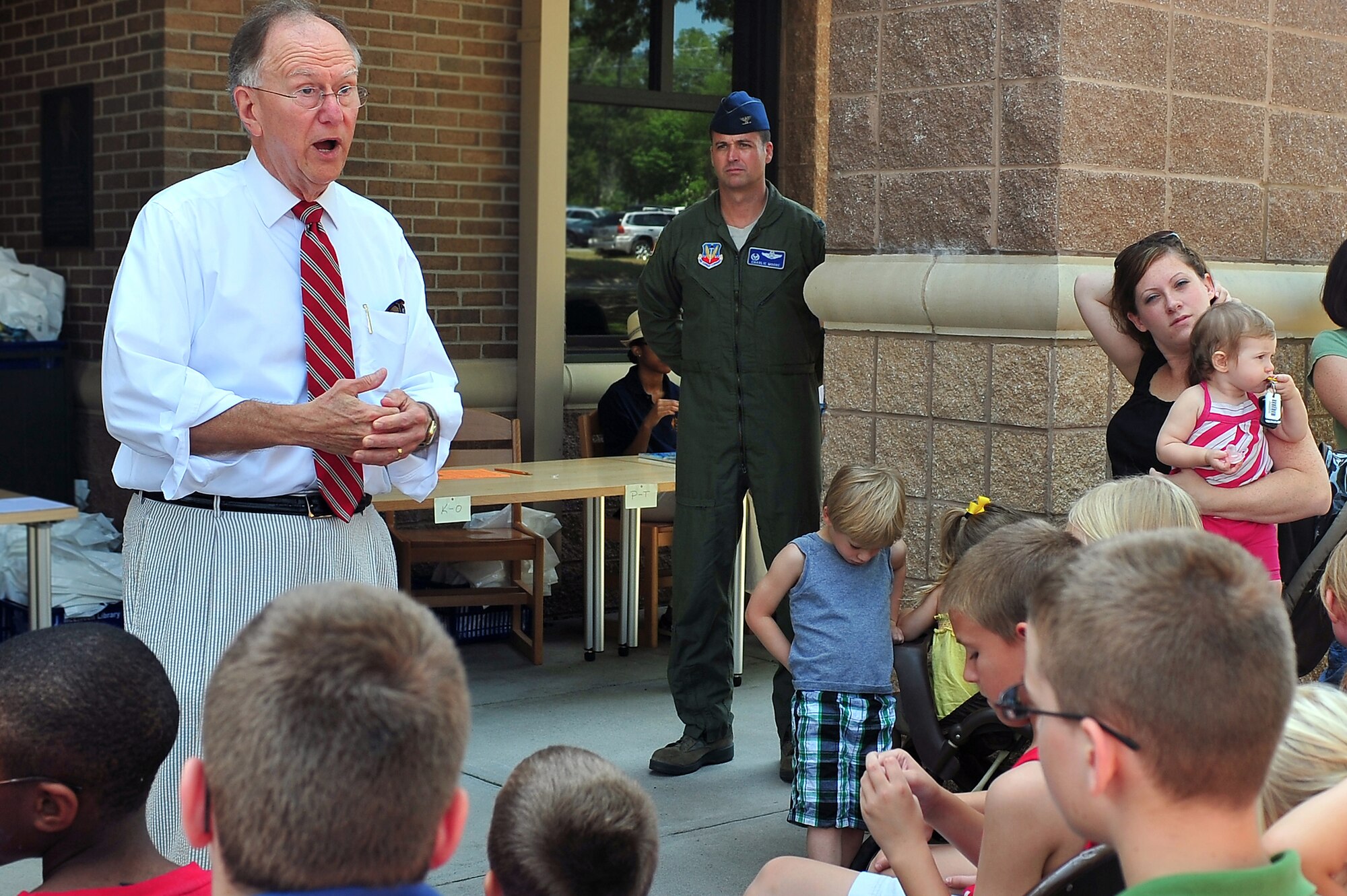 SHAW AIR FORCE BASE, S.C. -- Sumter mayor Joseph T. McElveen explains to the younger generation how important it is to read as Col. Charlie Moore, 20th Fighter Wing commander listens, during the kickoff for 'A Midsummer Knight's Read,'  the Department of Defense summer reading program, at the McElveen Library here, June 13, 2011. This event is held every year to encourage the children to read. (Airman 1st Class Ashley Gardner (Released).