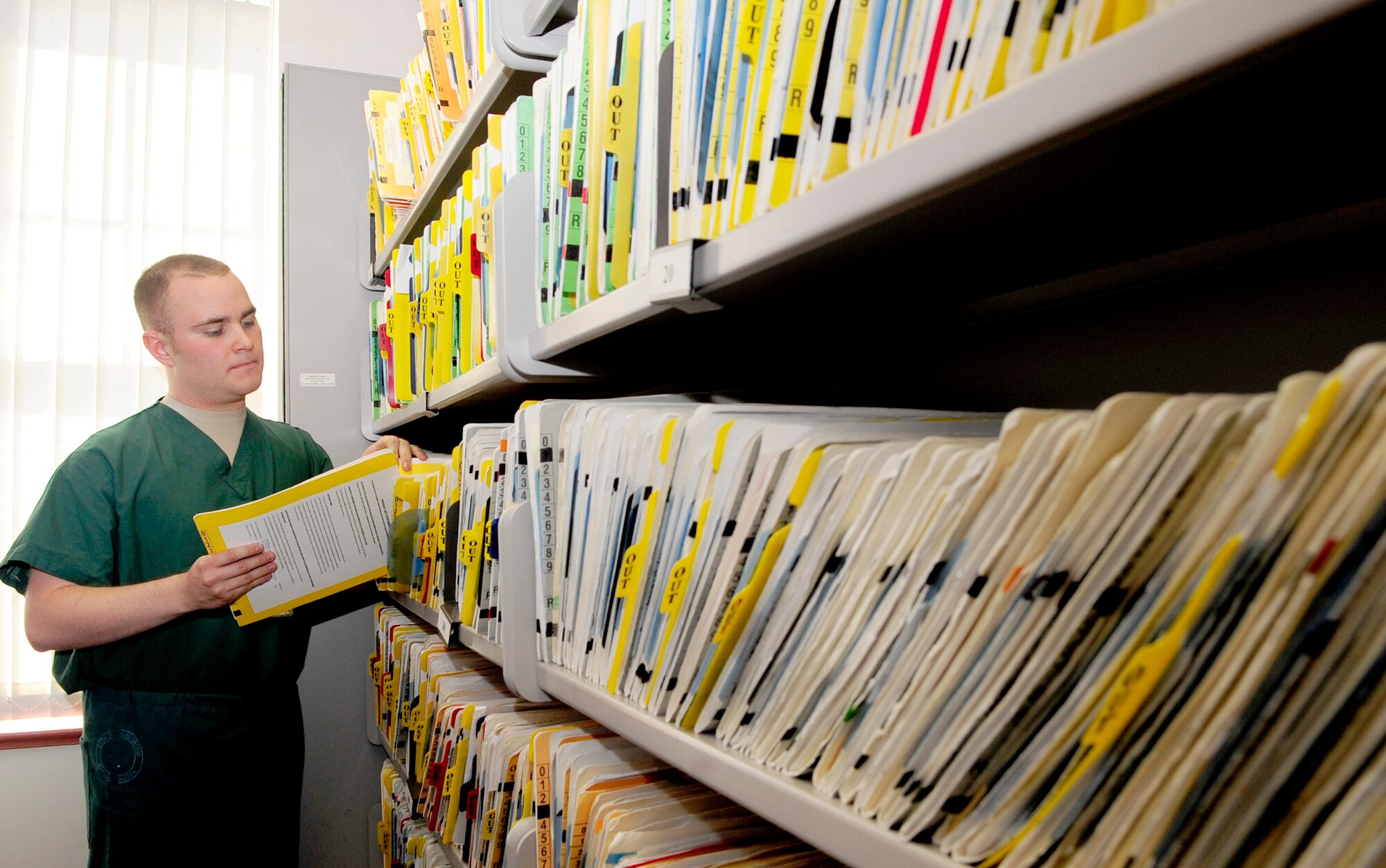 RAF MILDENHALL, England -- Senior Airman Joseph Bateman, 48th Dental Squadron technician, pulls a patient's dental records while preparing for their routine cleaning here Jun 14, 2011. Each patient's file is pulled before treatment so that their identity can be confirmed and they are given the correct treatment. (U.S. Air Force photo/Senior Airman Ethan Morgan)